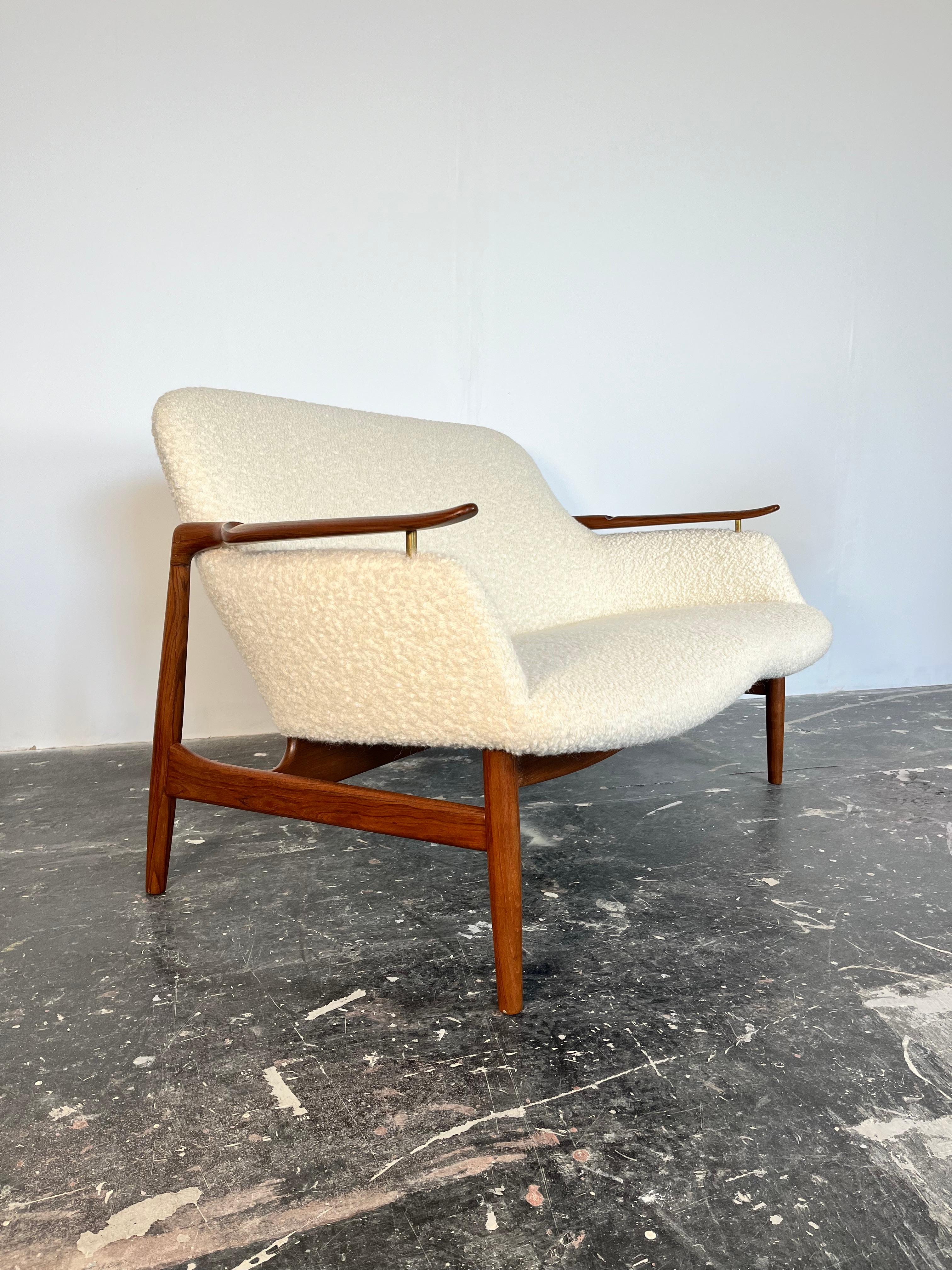 A rare example of the stunning, sculptural settee by Danish design pioneer Finn Juhl. The NV-53 is named after its cabinetmaker, Niels Vodder, and the year of its design, 1953. Its biomorphic shape—influenced by the Surrealists—and unique, floating