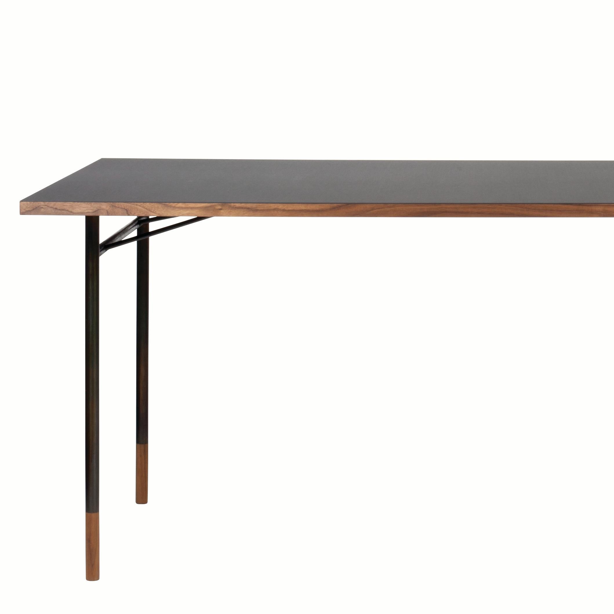 Bureau de table conçu par Finn Juhl en 1945, relancé en 2009. Fabriqué par la Maison Finn Juhl au Danemark.

Au cours de sa carrière, Finn Juhl a conçu une série de tables différentes avec des pieds presque invisibles en acier bruni ou peint avec
