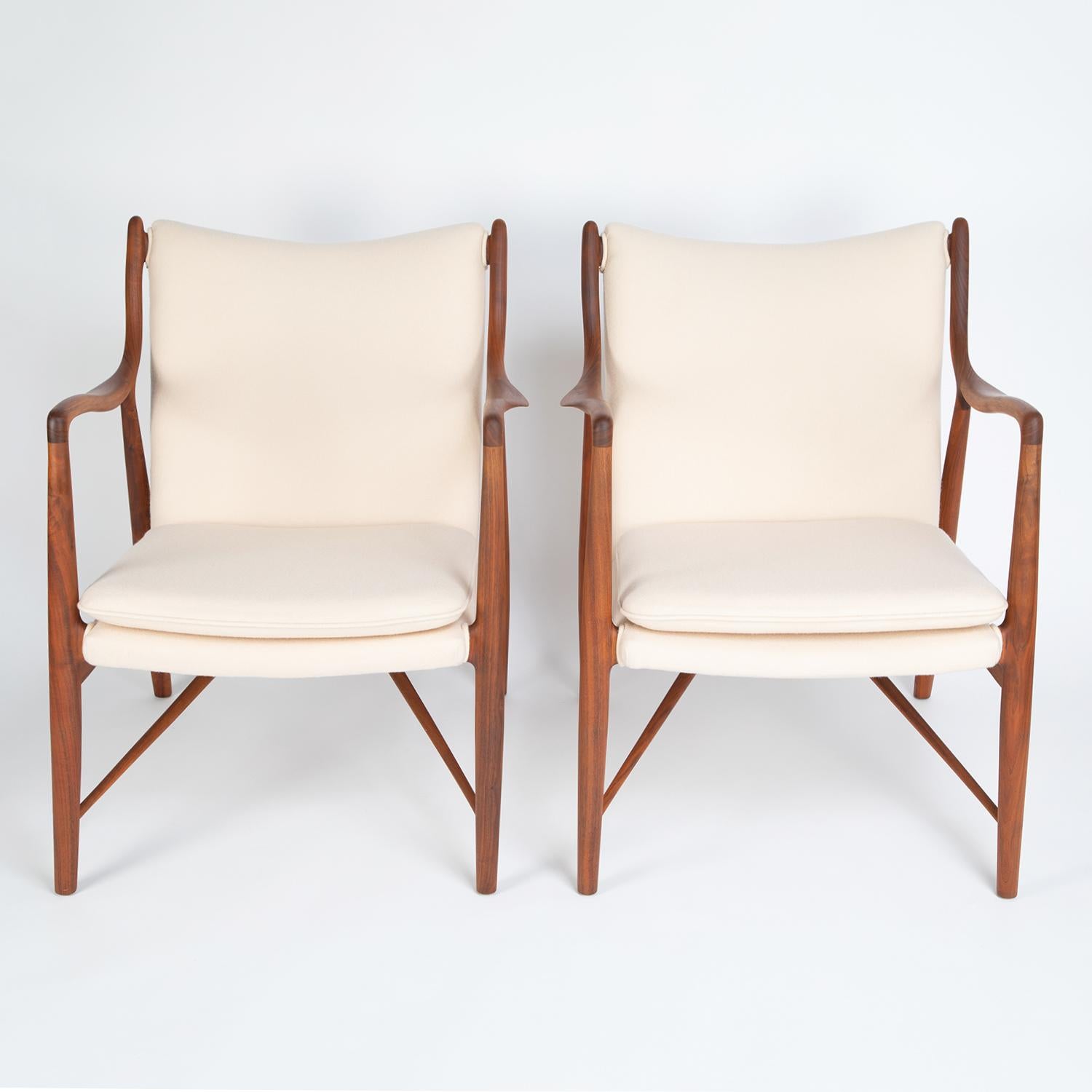 Pair of model NV-45 lounge chairs with sculptural walnut frames and upholstered seats and backs by Finn Juhl (Denmark) for Baker Furniture, American, 1950s. These chairs were originally produced by Neils Vodder in Denmark and subsequently produced