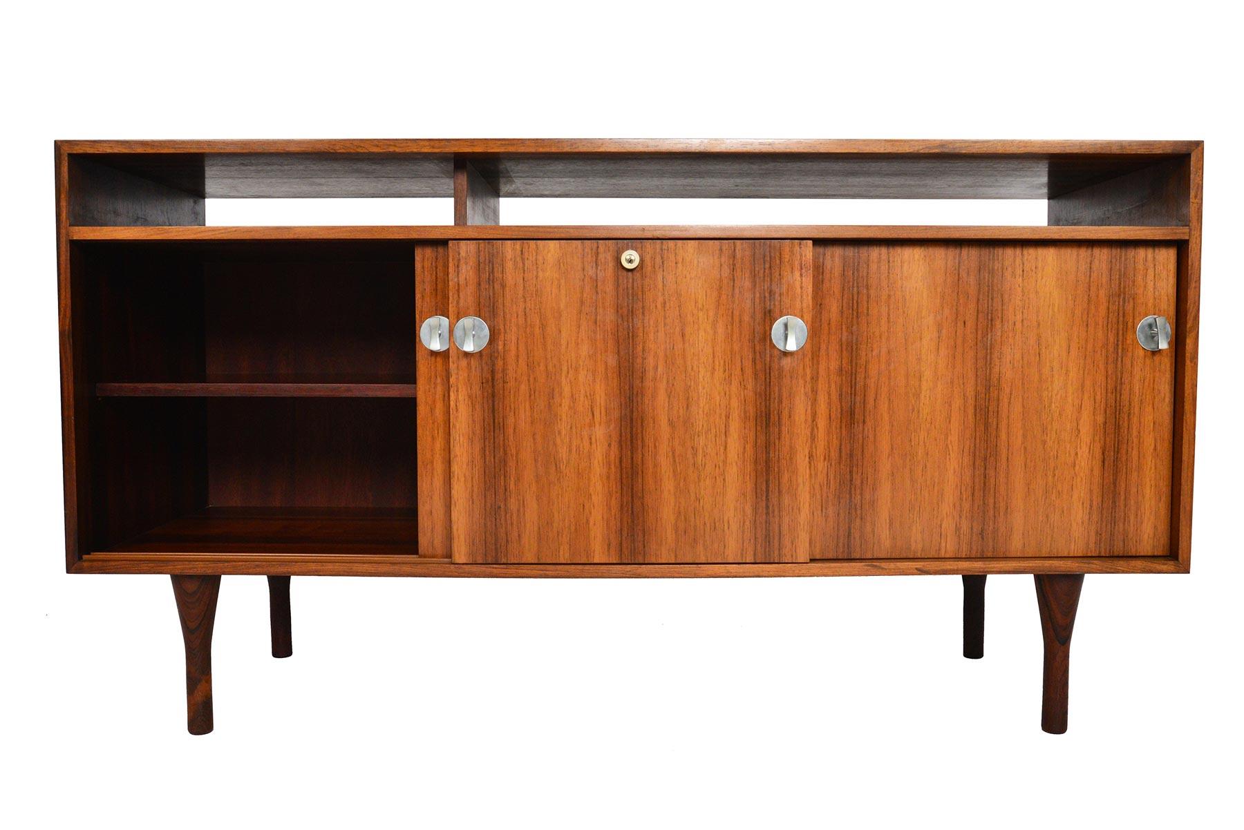 Designed by Finn Juhl for France and Son in 1958, this rosewood credenza from the “Diplomat” range is a sophisticated blend of clean lines and modernist embellishments. Keeping the design airy, two cubbies sit above the cabinet. Three sliding doors