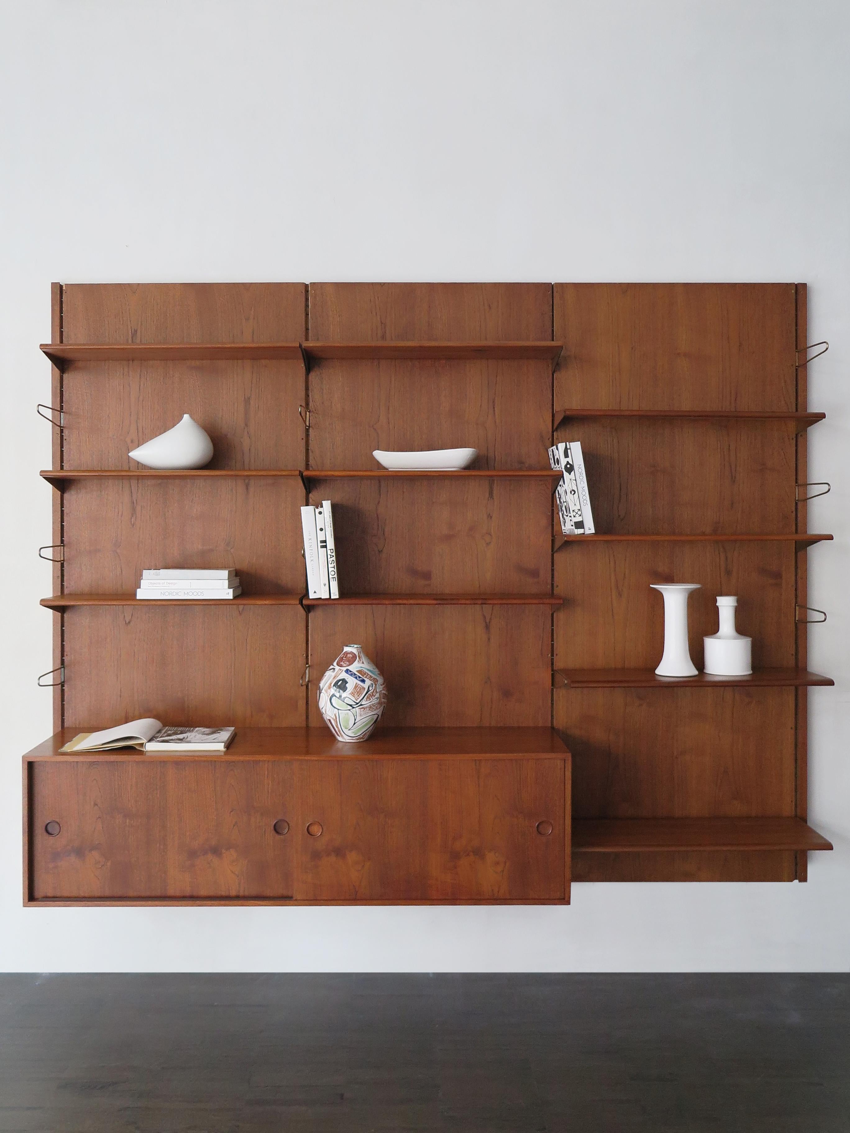 Scandinavian teak bookcase shelves or panel system designed by Finn Juhl and produced by Bovirke composed of 10 shelves and 1 container with sliding doors, both the shelves and the container can be positioned as desired, brass details, Denmark