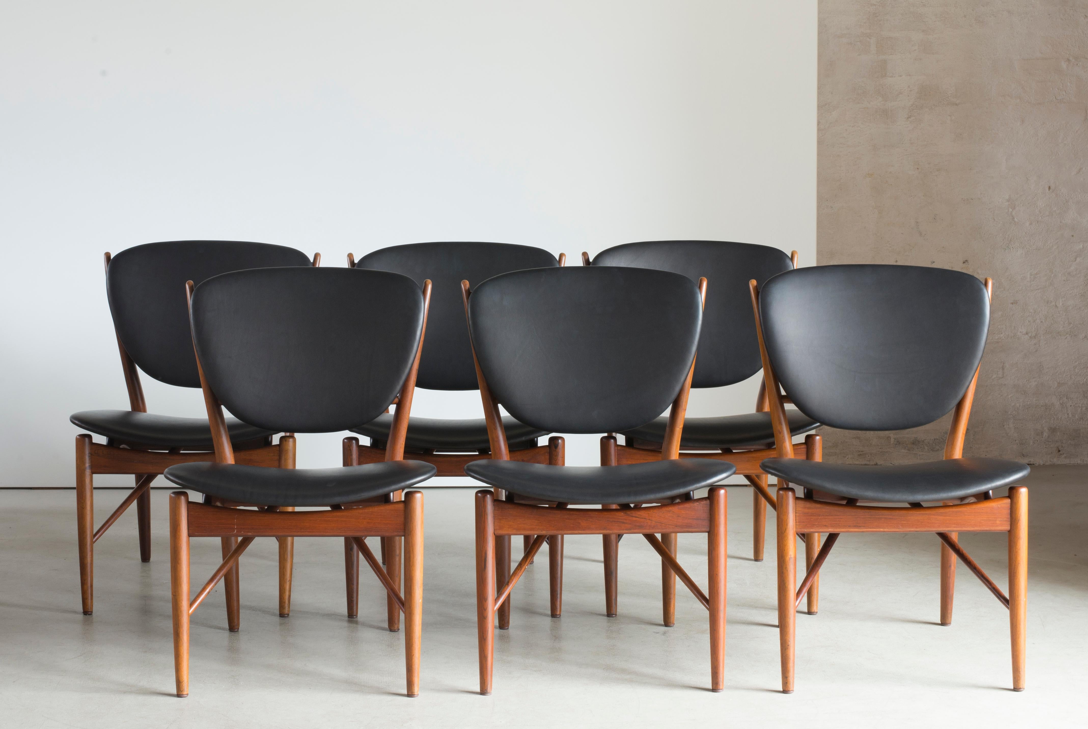 Finn Juhl set of six chairs of rosewood. Seat and back upholstered with black leather. 

Executed by cabinetmaker Niels Vodder, Copenhagen, Denmark. Underside of each chair branded CABINETMAKER Niels Vodder/COPENHAGEN DENMARK/DESIGN: Finn Juhl.