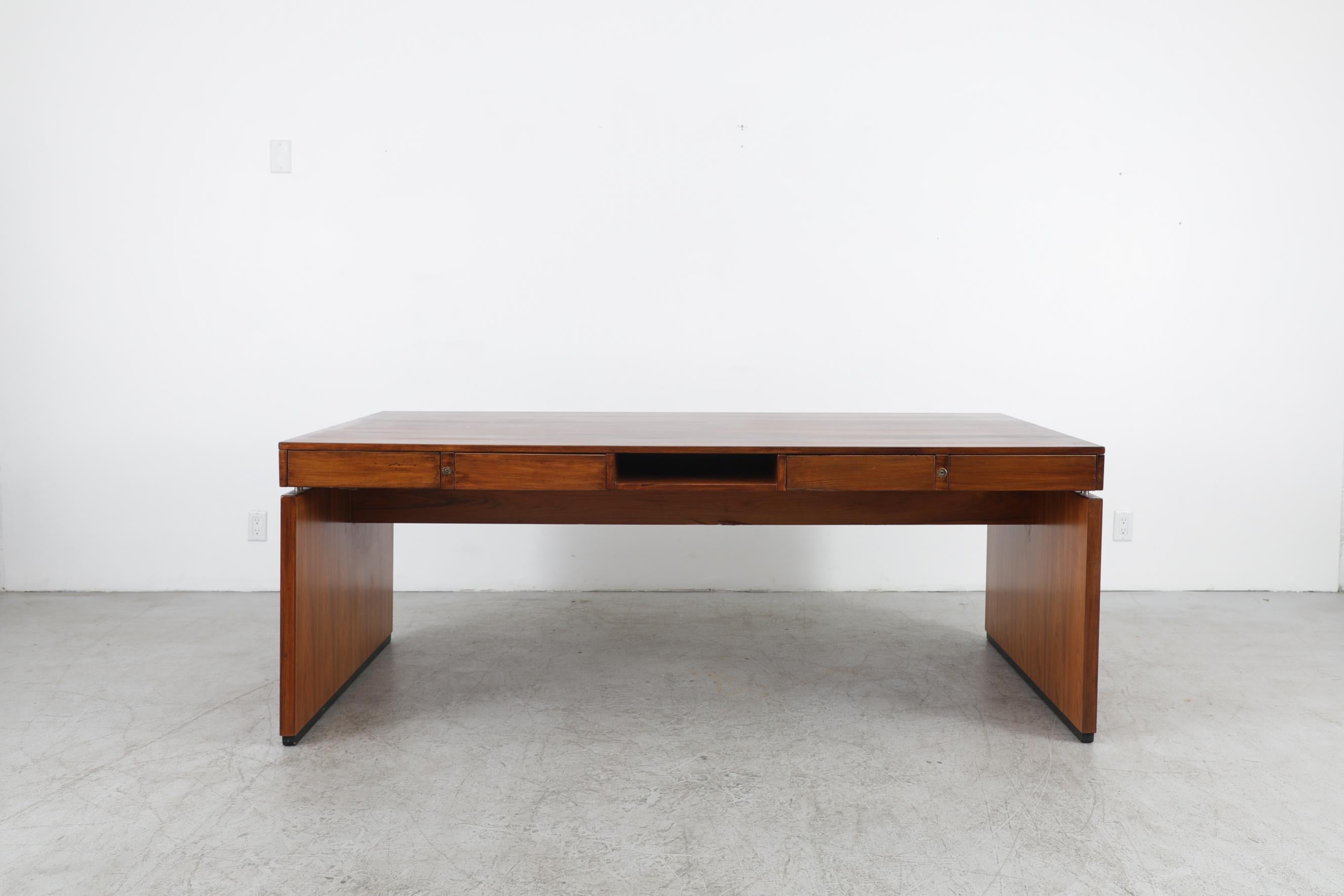 Finn Juhl style rosewood executive desk with brushed steel details and 4 drawers. Striking design with waterfall style legs.
In original condition with visible wear including some scratches and chips to the middle base. The wear is consistent with