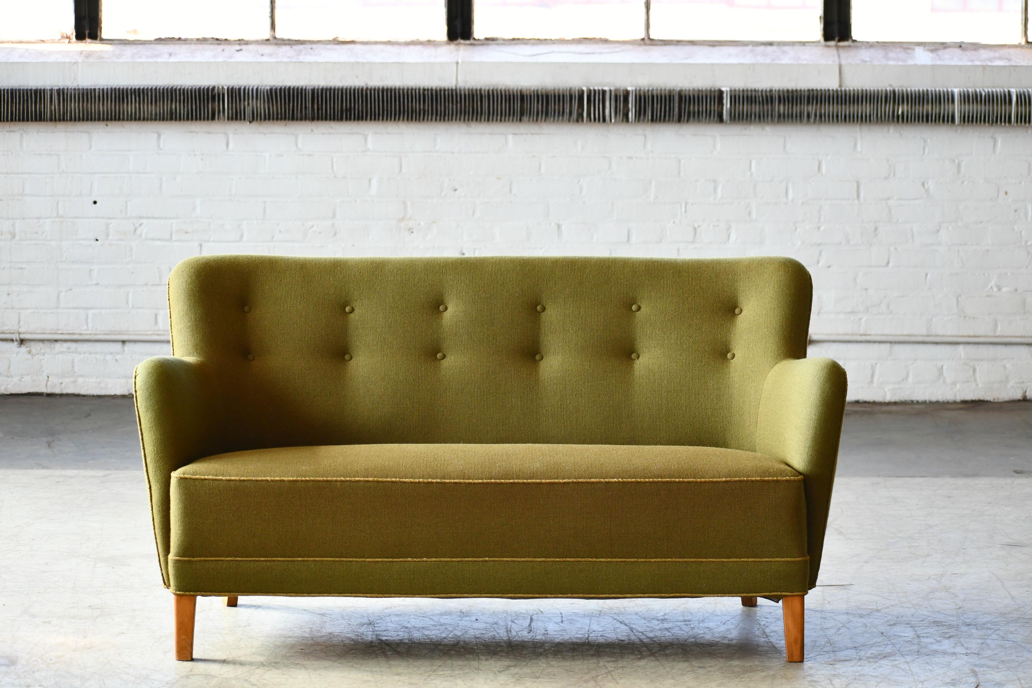 Superbly elegant Finn Juhl style sofa or settee made by Slagelse Mobelvaerk, Denmark sometime in the 1940s. Perfectly balanced lines and proportions providing for a solid and sturdy yet very elegant design. The sofa was re-upholstered in a nice