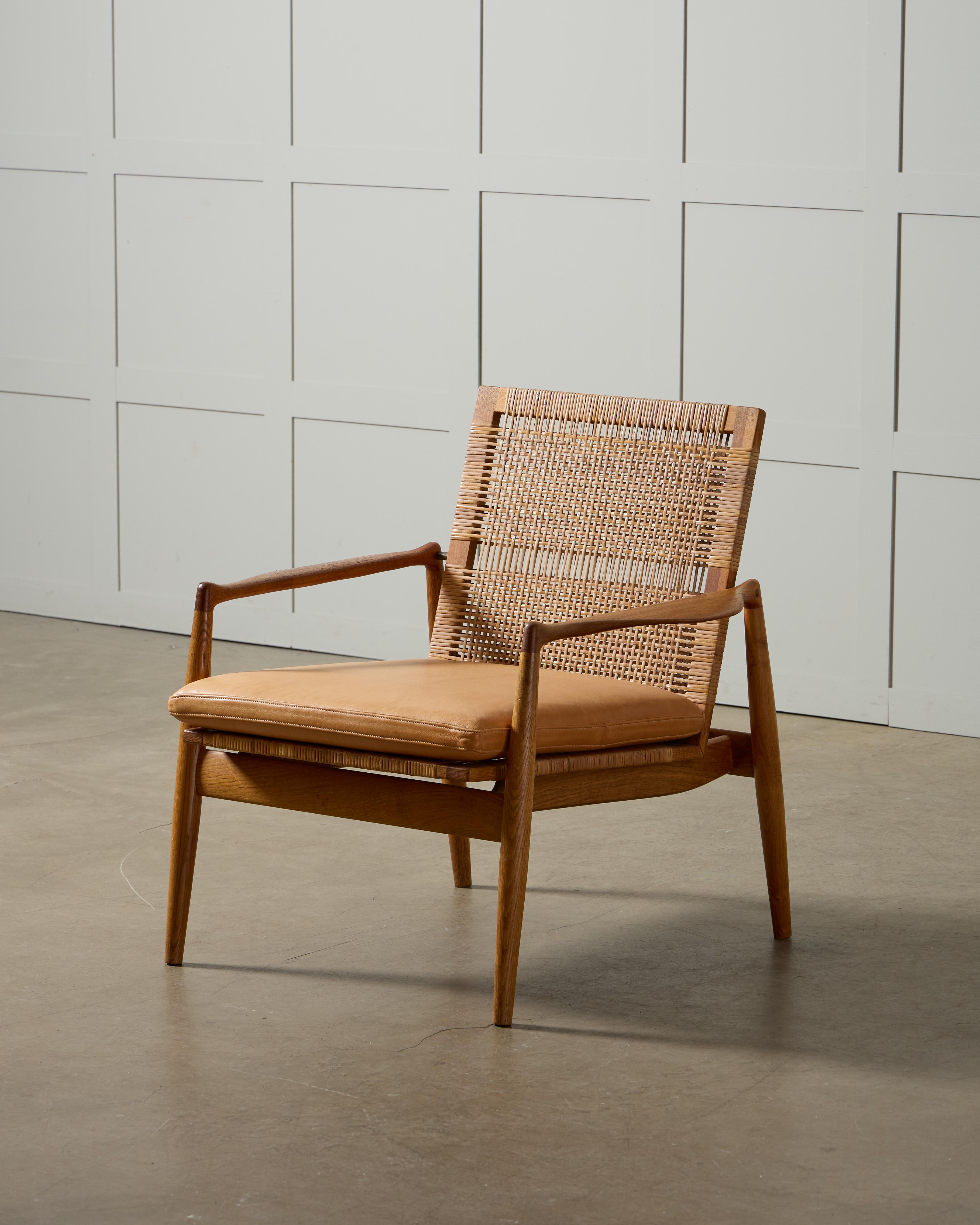 Este excepcional sillón de salón modelo SW-96, diseñado por el famoso arquitecto danés Finn Juhl en 1954, muestra su característico enfoque de las formas orgánicas y una artesanía impecable. Construida con una hermosa combinación de teca y roble, la