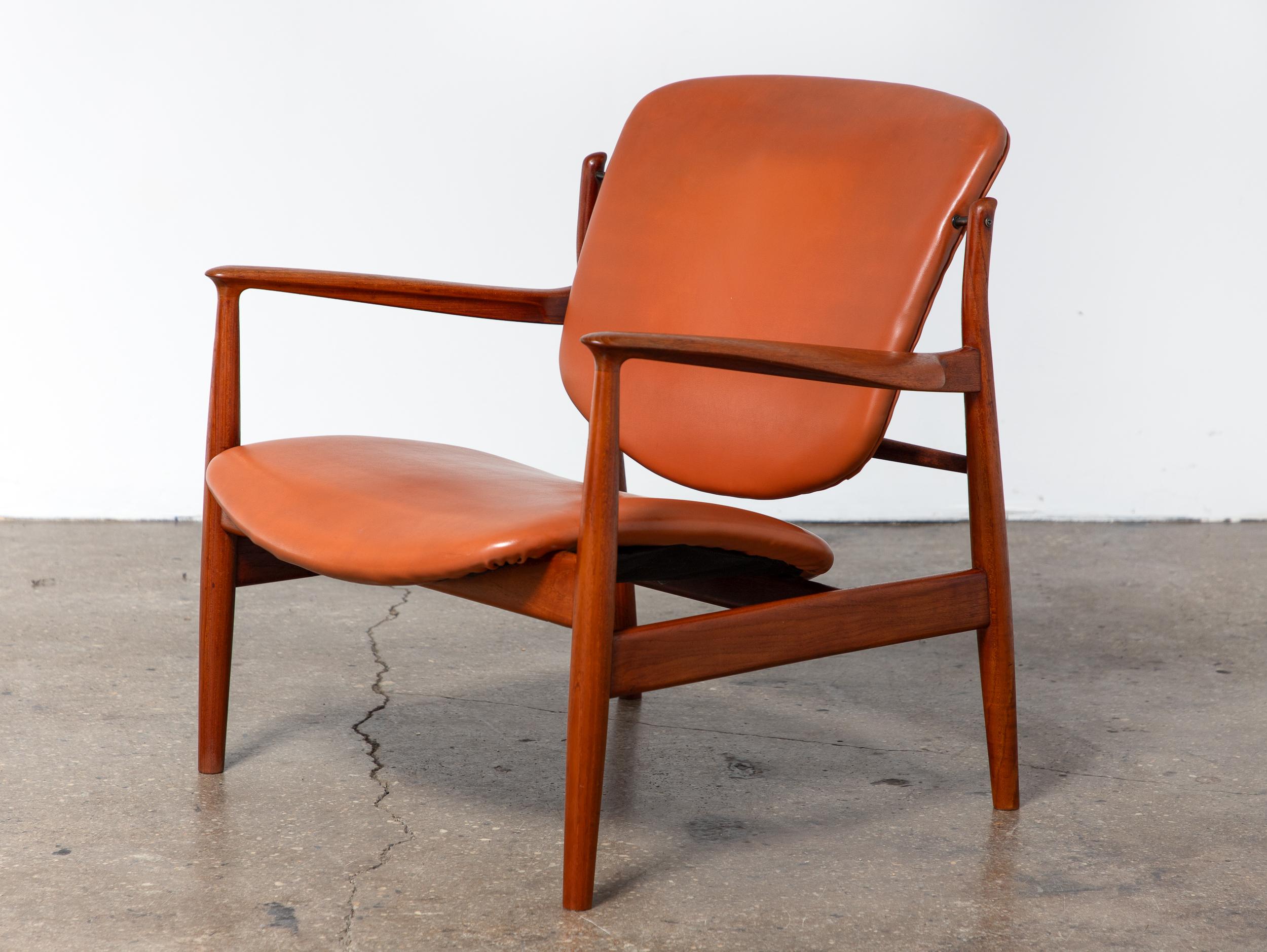 Modelo FD-136 Silla de salón, diseñada por Finn Juhl para France & Daverkosen, importada por John Stuart. La escultural estructura de teca presenta el característico respaldo flotante del diseñador danés y un asiento sutilmente contorneado. La