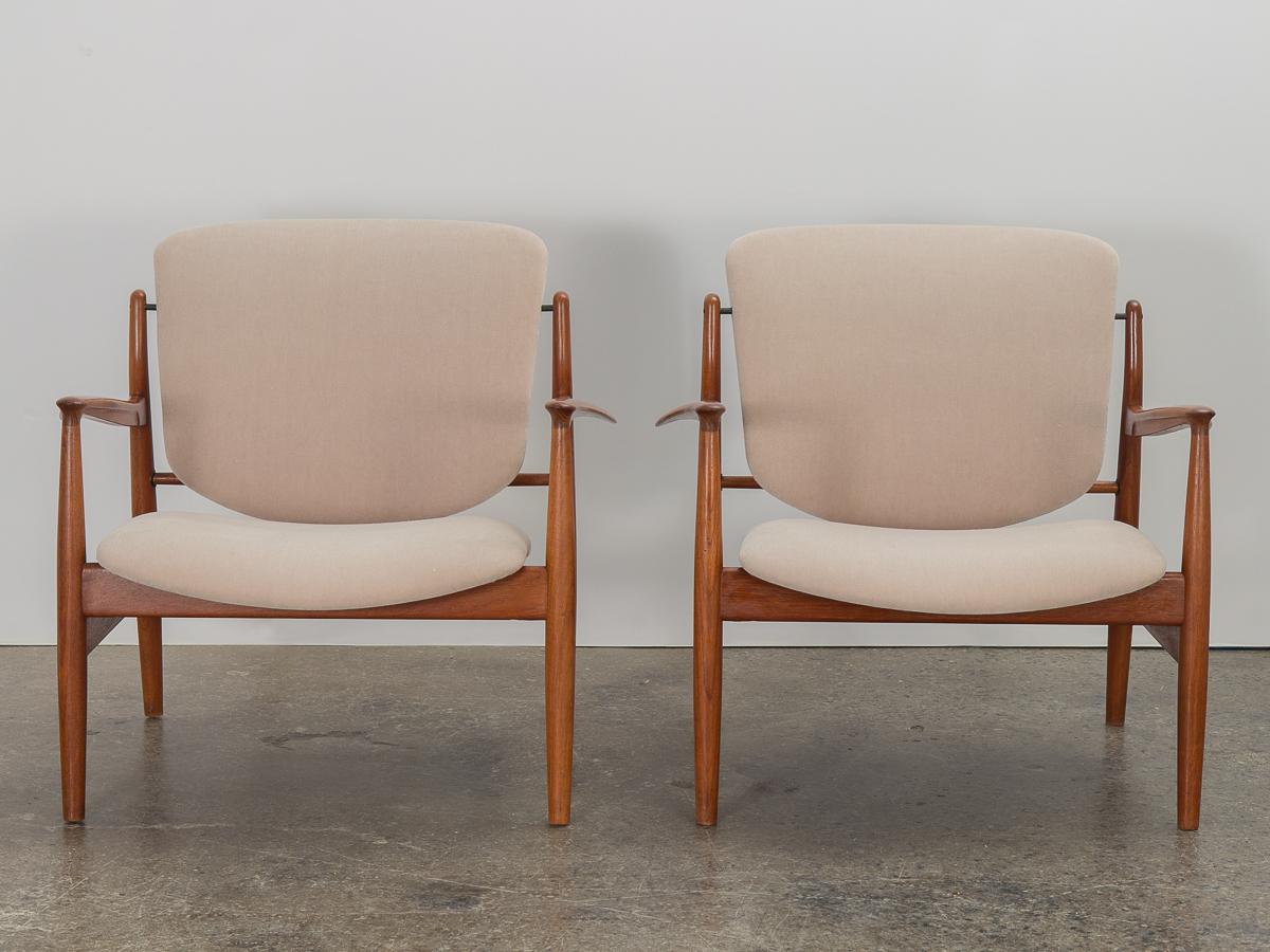 Pair of iconic model FD-136 Lounge Chairs in teak, designed by Finn Juhl for France and Daverkosen, imported by John Stuart. Sculptural open frame showcases choice teak wood, which is beautifully figured and gleaming. Special attention is paid to