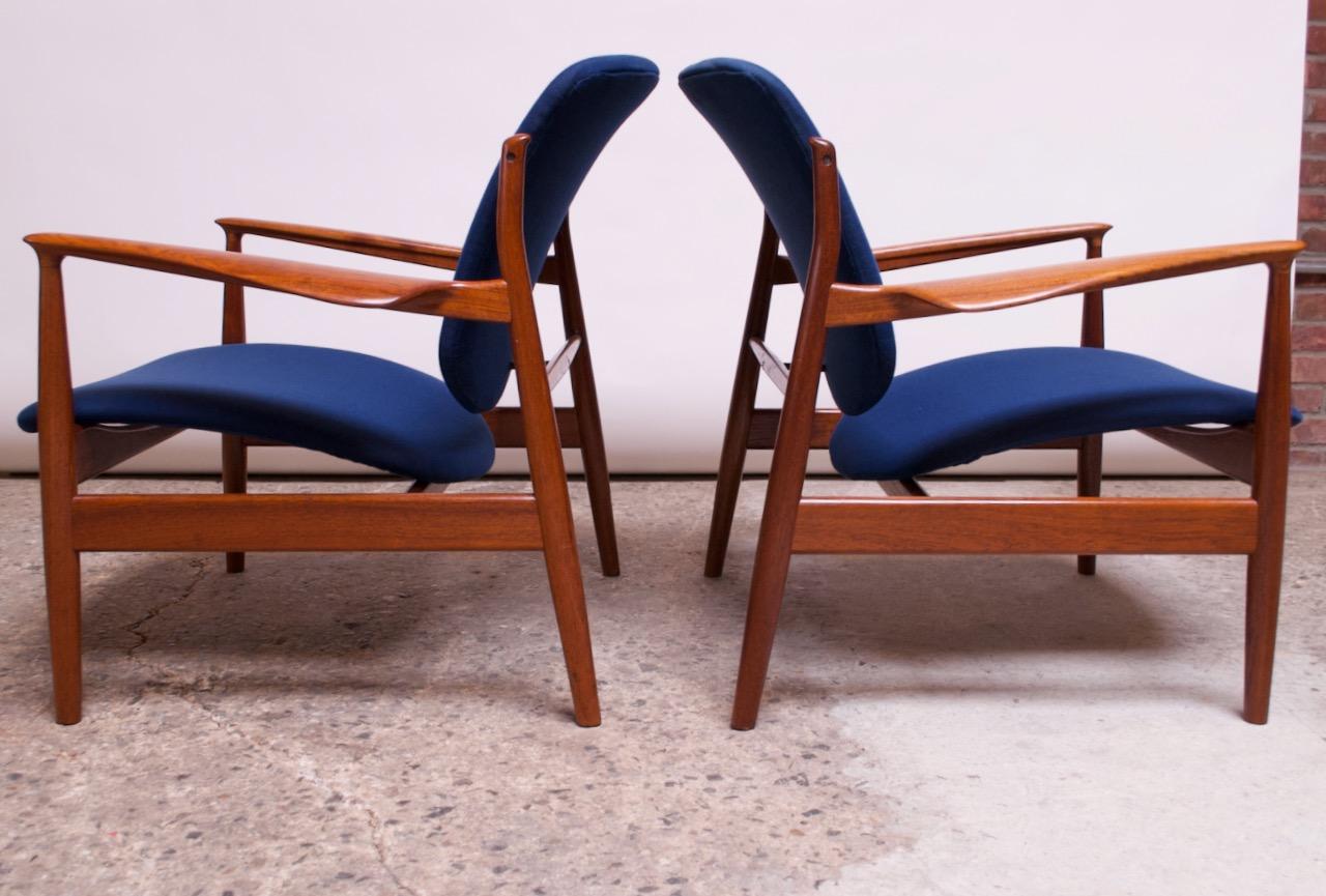 Pair of 1950s Danish modern lounge chairs (model FD 136) designed by Finn Juhl. Early examples produced by France & Daverkosen, the predecessor to France & Son.
Boasts broad, floating back rests, wide seats, and elegantly sculpted teak arm rests.