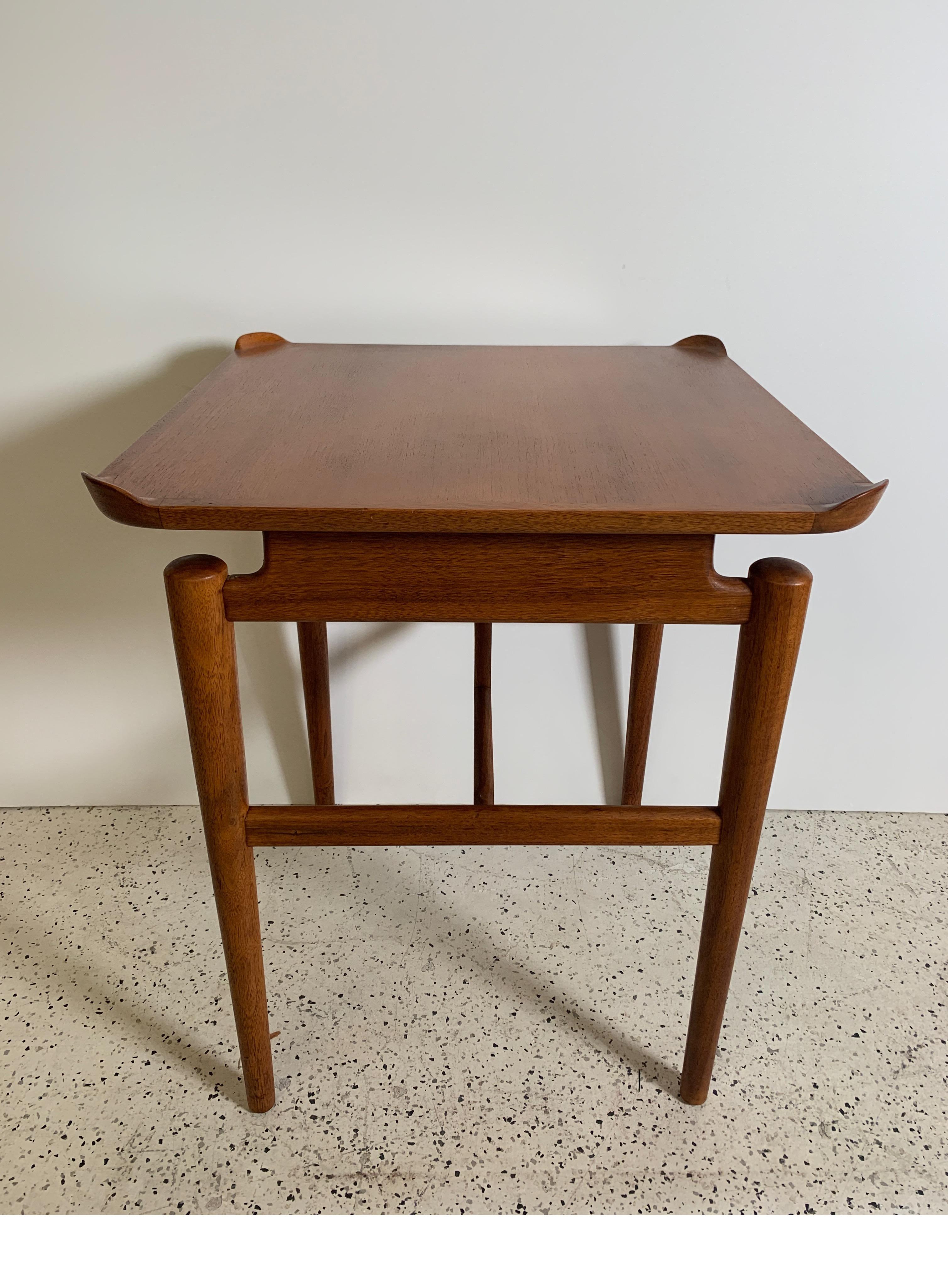 Lovely and uncommon sculpted, floating top end table in walnut designed by Finn Juhl for Baker Furniture Company, USA, 1954. The elegant lines in this piece, as well as in certain other pieces of his work, testify to the inspiration Juhl got from