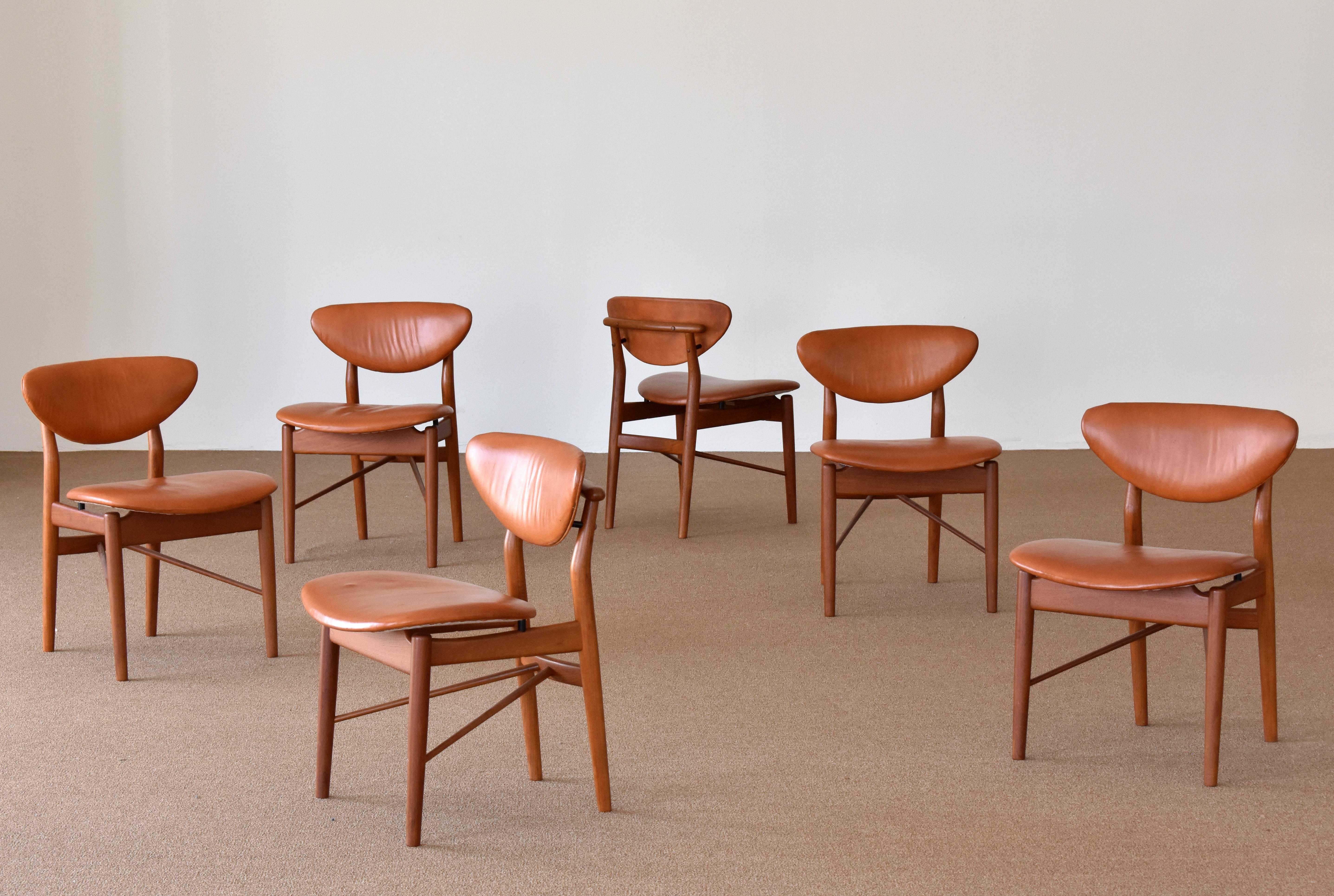 Finn Juhl, a set of six dining chairs model NV-55. Handcrafted in the cabinet maker studio of Niels Vodder, Copenhagen Denmark. Branded Niels Vodder. Brown patinated leather and teak frames. 

Designed in 1955, this group likely produced in late