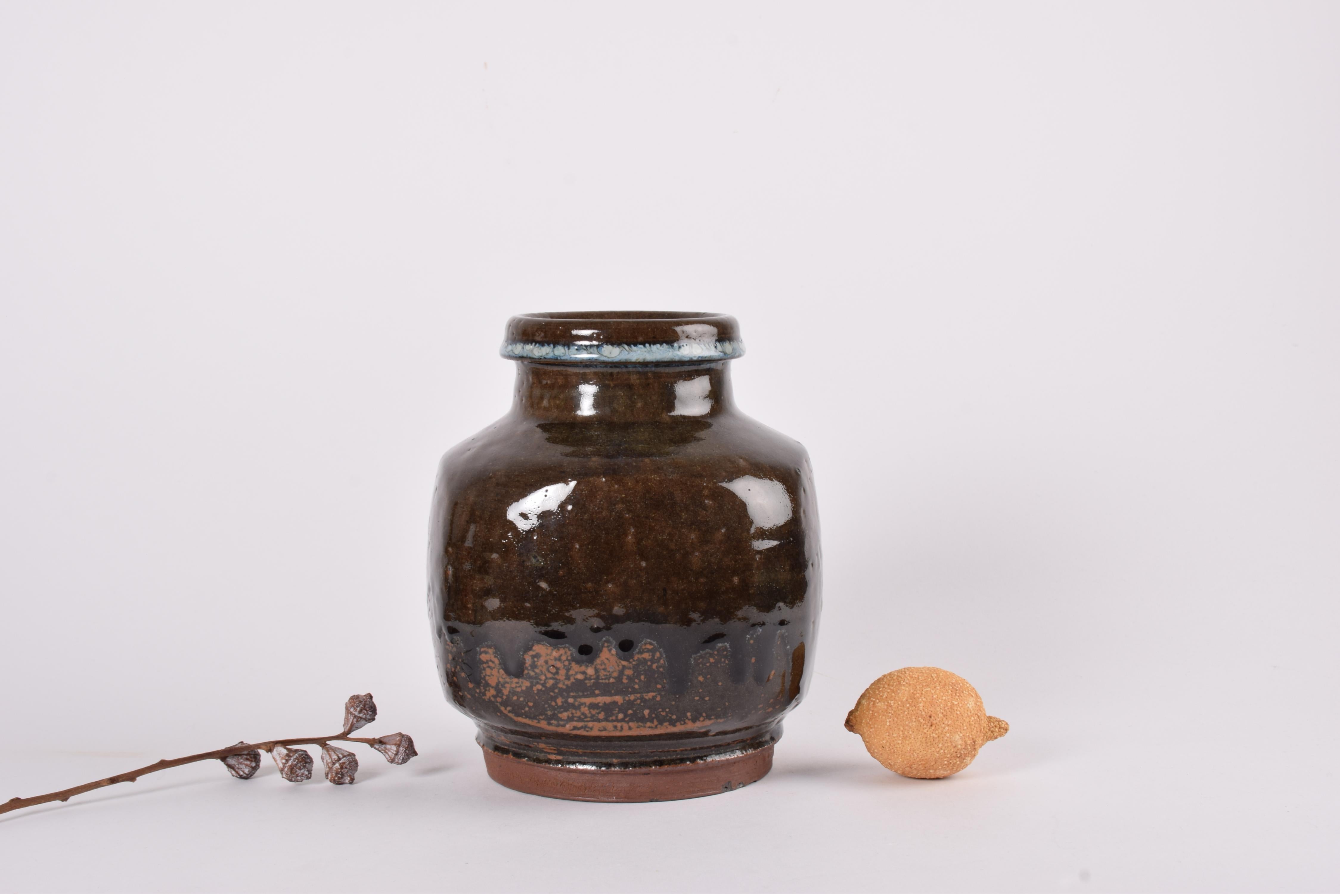 Large ceramic vase by Danish ceramist and glass artist Finn Lynggaard (1930-2011). Made in Finn Lynggaard´s own studio ca 1960s to 1970s.

It features a dark brown glaze with rust red elements and partly drip glaze and a rim with blue glaze. It has