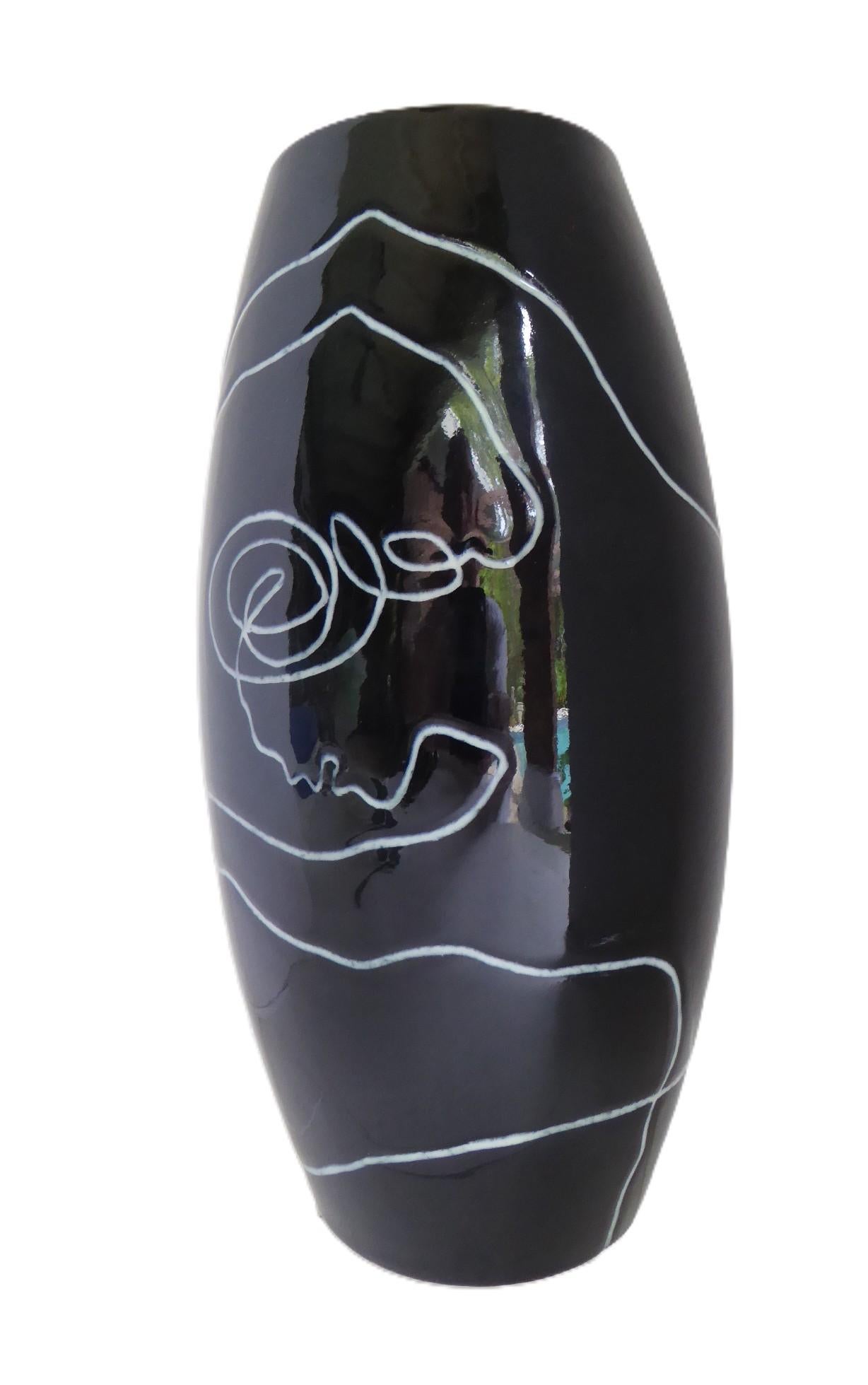 Precioso jarrón de cerámica finlandesa moderna de la serie Pro Arte, de Pauli Vuorisalo, para Arabia. Un estilístico diseño abstracto de una dama en pose de ballet está tallado en el esmalte negro brillante de la arcilla blanca del cuerpo. 
Firmado