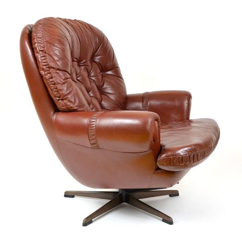 Finnish leather armchair that can be set to an almost horizontal position and that can rock. The frame is covered in artificial leather with the backrest and seat are made from leather, all original condition with sings of use. Manufactured in
