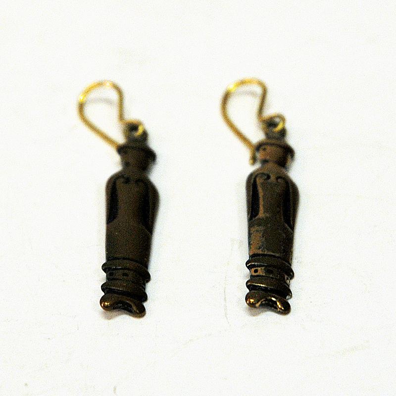 A rare pair of bronze ear rings with peoples motive designed by Kirsti Ilvessalo for Kalevala Koru, Finland 1950s. The ear rings are of two similar women in straight up position and with old clothing. Hook fixings. 
Hallmarked on the back by