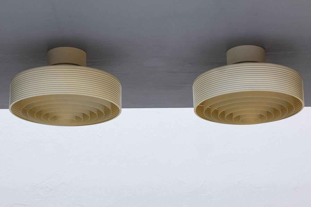 Paire de lampes de plafond conçues et fabriquées par iValo en Finlande au cours des années 1970. Les luminaires sont en aluminium laqué. Ils restent en très
bon état vintage avec la couleur d'origine patinée par le temps et l'usage.