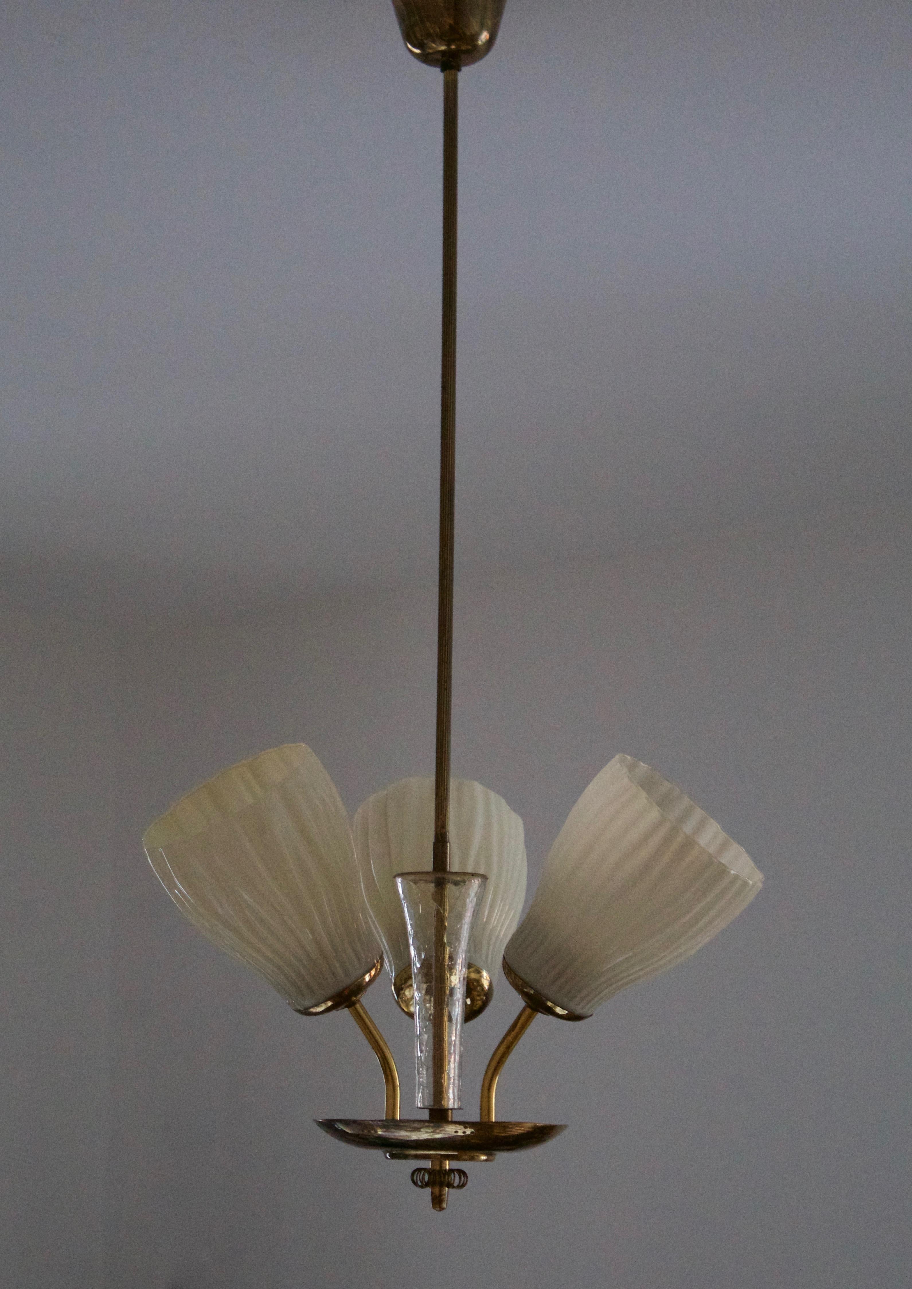 A chandelier light, designed and produced in Finland, 1940s. Features milk glass with organic ornamentation, blown glass, and finely detailed brass. 

Other designers of the period include Paavo Tynell, Alvar Aalto, Lisa Johansson-Pape, J.T.