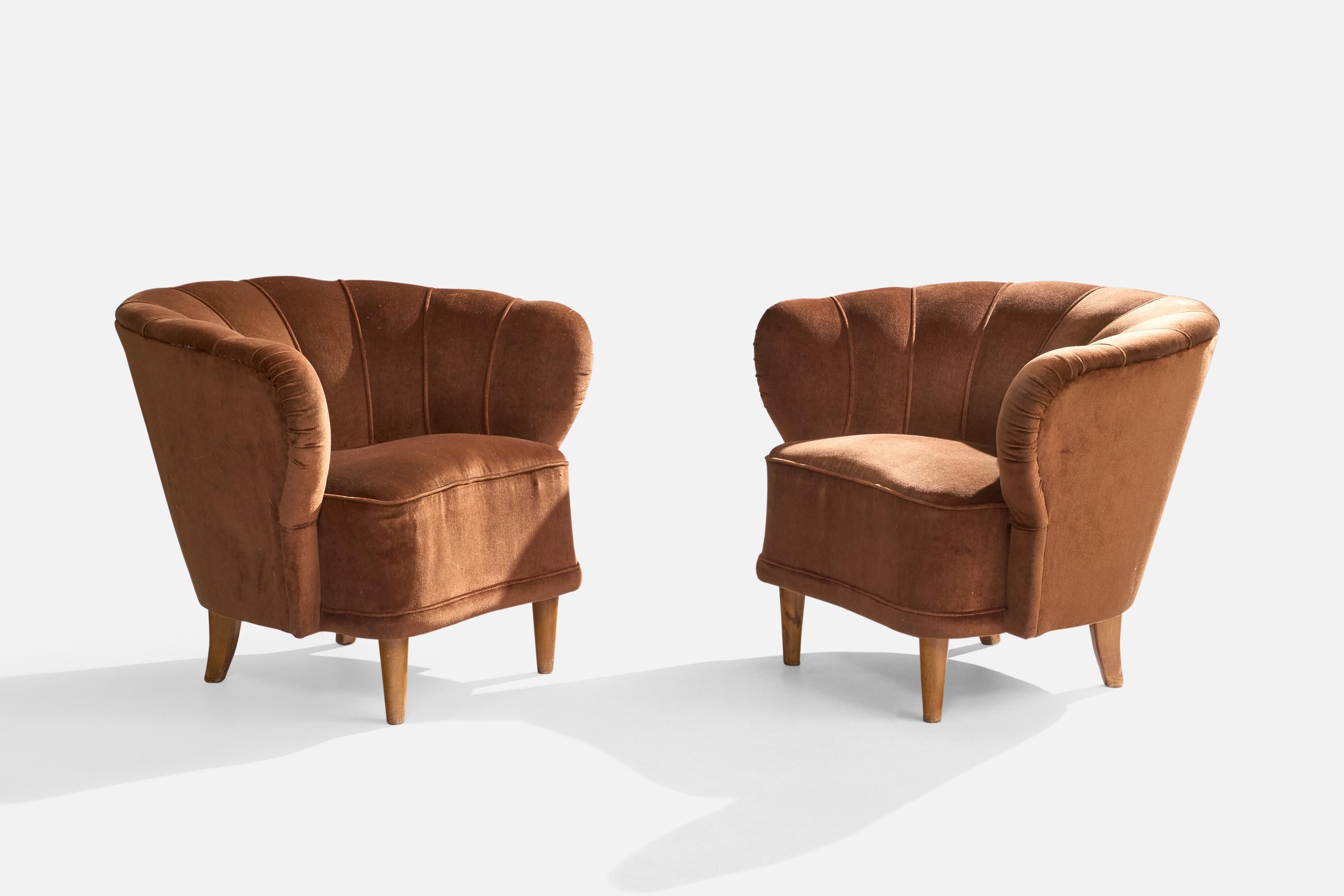 A pair of wood and brown velvet fabric lounge chairs designed and produced in Finland, c. 1940s.

In unrestored condition, with lively patina to wood and vintage fabric in distressed condition, ideally reupholstered.

Overall Dimensions (inches):