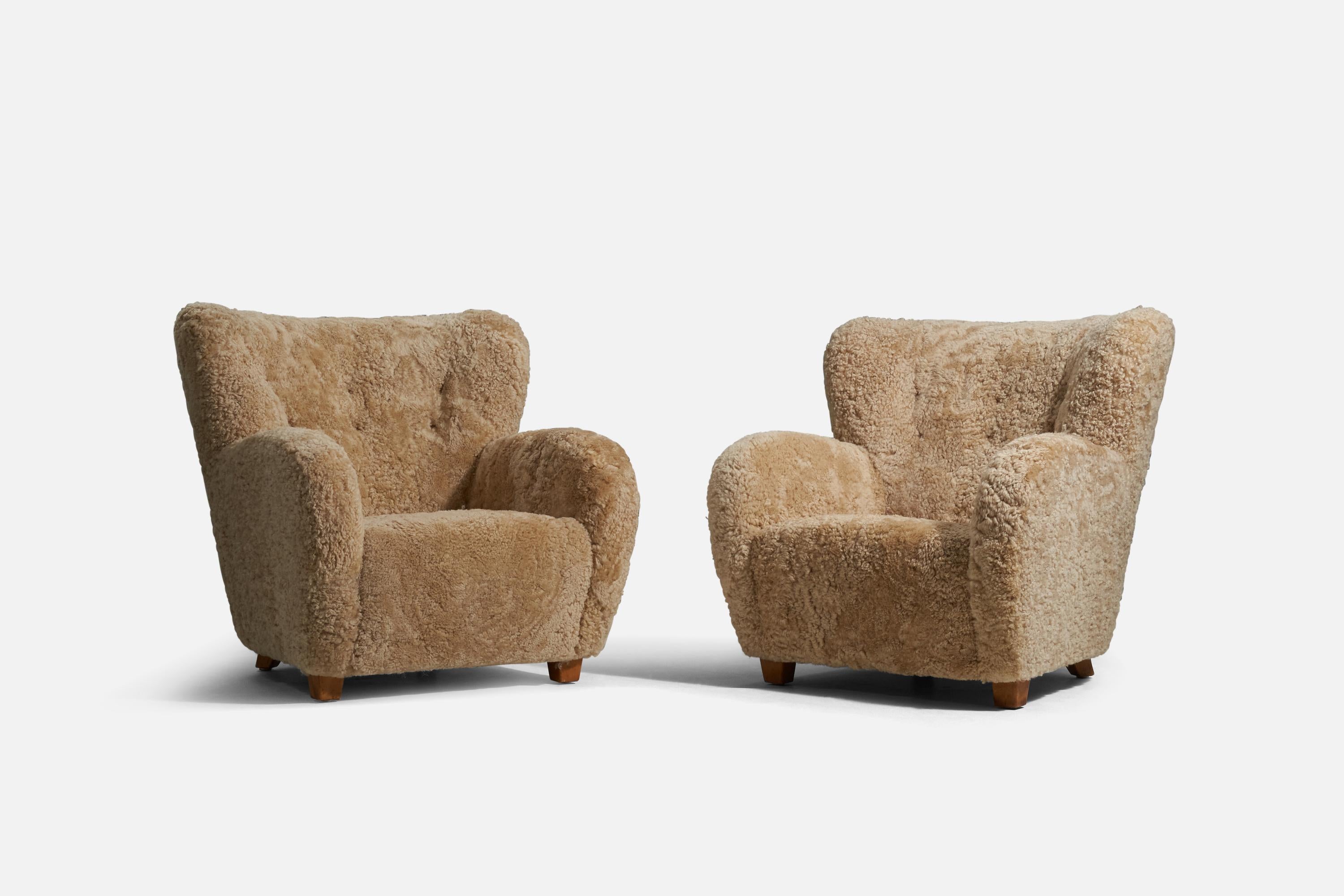 A pair of shearling and beech lounge chairs designed and produced by a Finnish designer, Finland, 1940s.