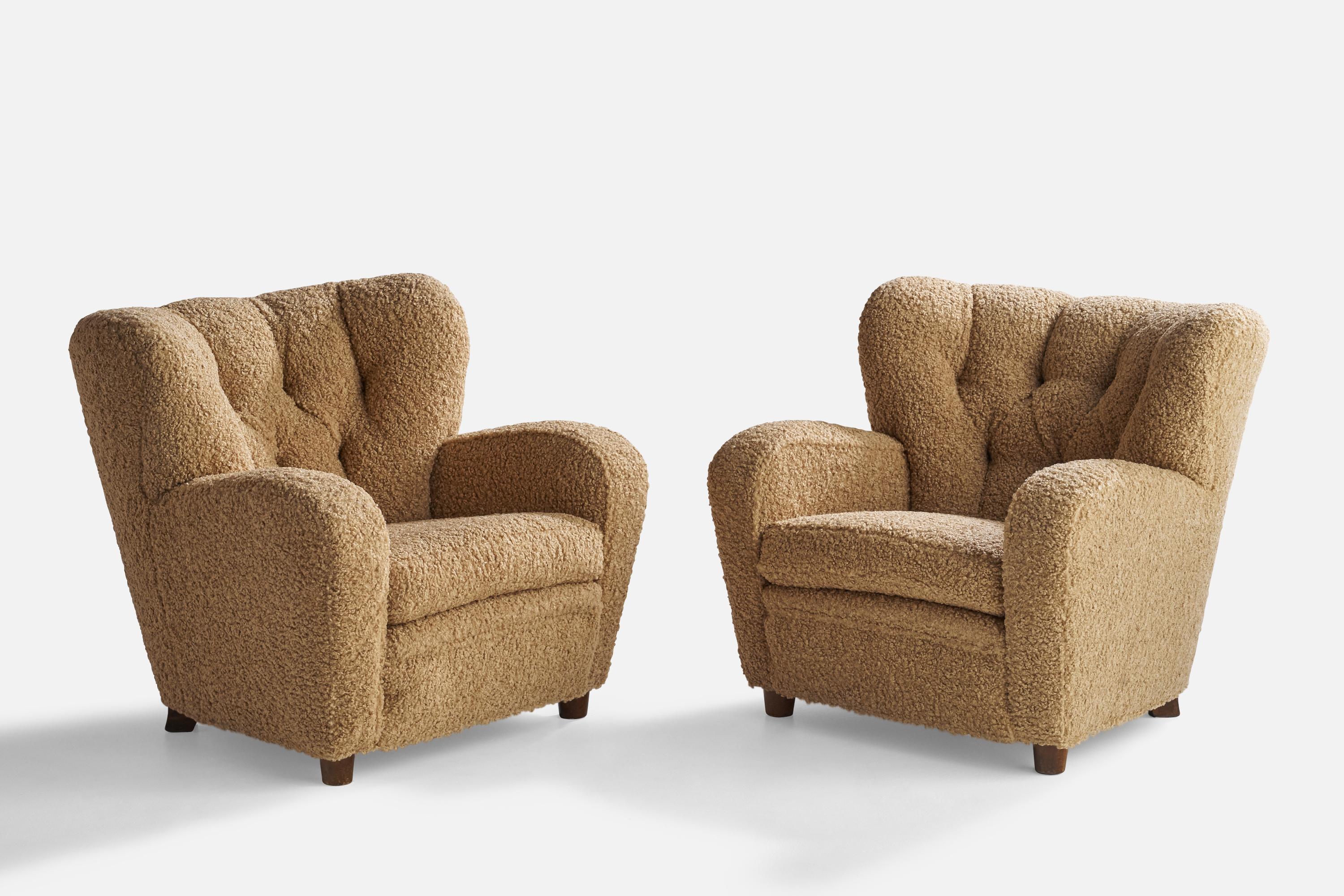 A pair of dark-stained birch and beige bouclé fabric lounge chairs designed and produced in Finland, 1940s.

Seat height 16.5