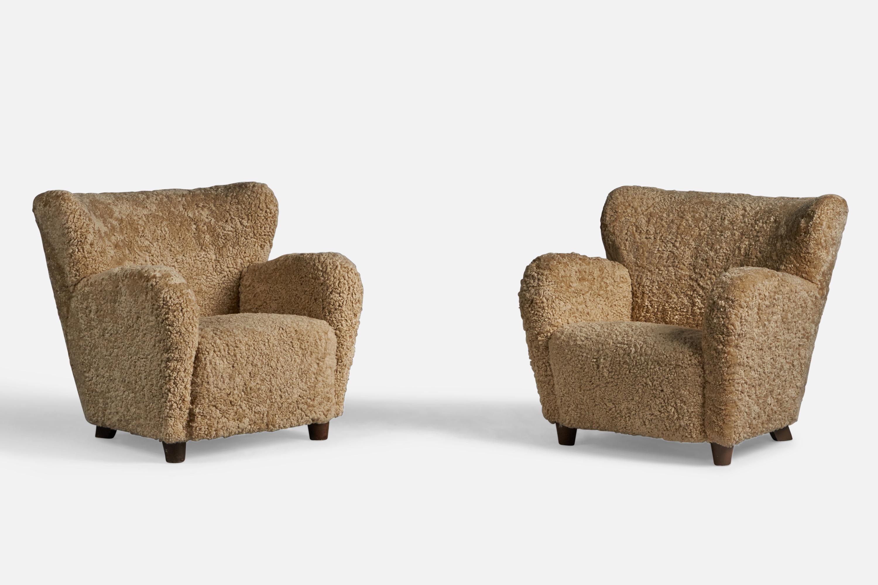 A pair of organic beige shearling and stained wood lounge chairs, designed and produced in Finland, 1940s.

15.5