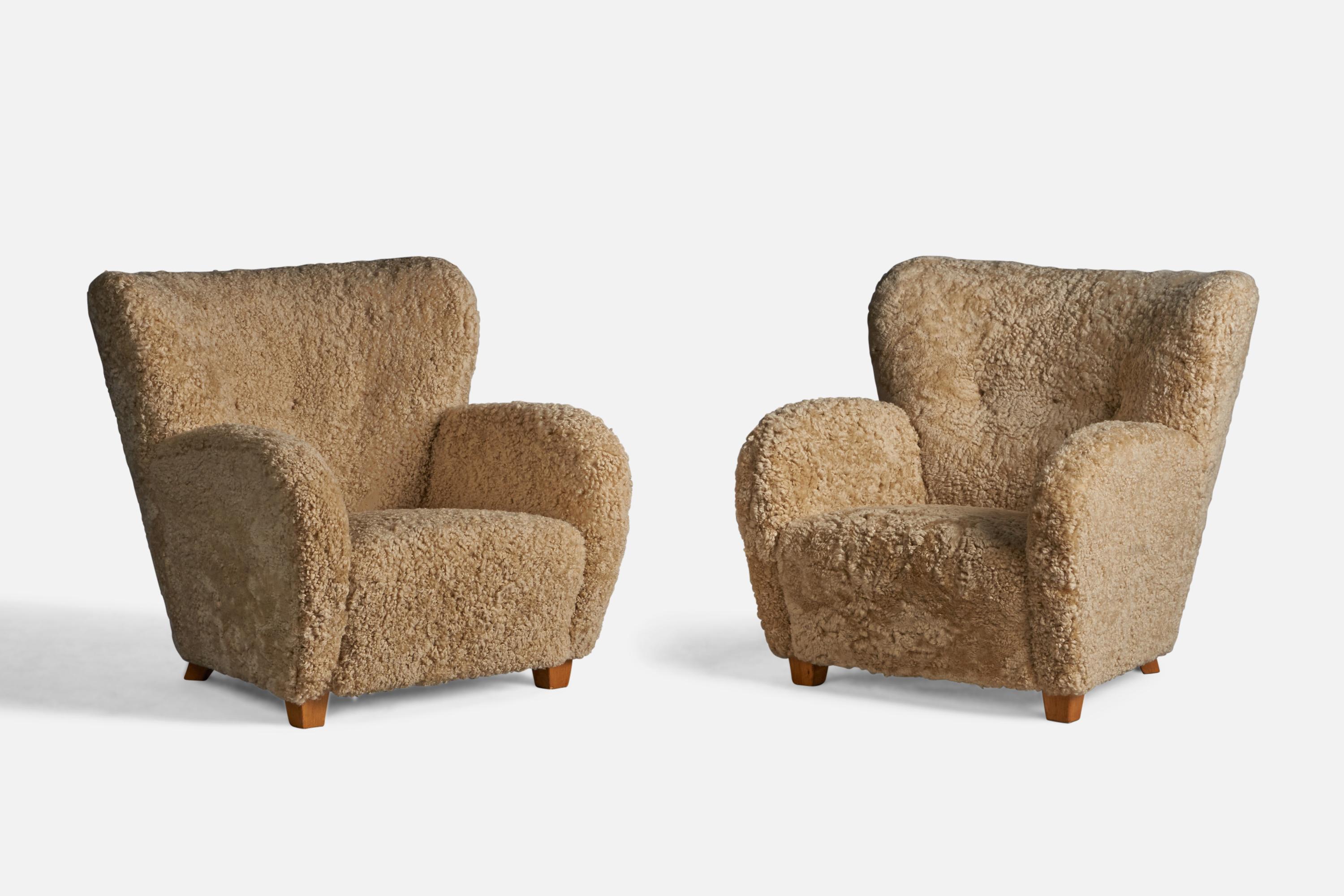 A pair of organic beige shearling and wood lounge chairs designed and produced in Finland, 1940s.

13.5
