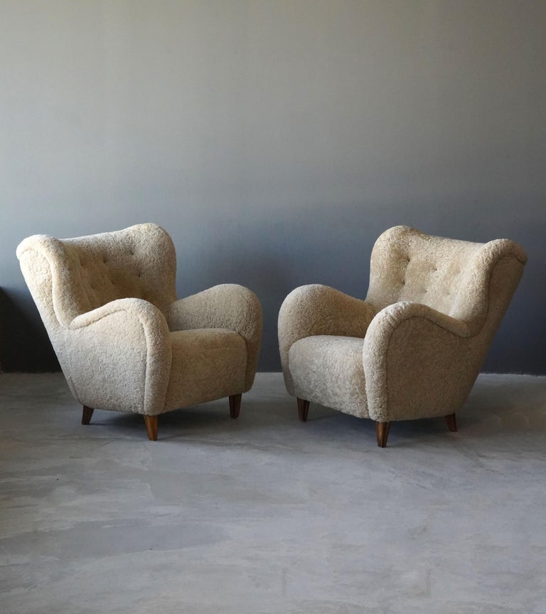 A pair of organic modernist lounge chairs. Designed and produced in Finland, 1940s. Reupholstered in brand new authentic shearling upholstery. 

Similar in style to works by designers such as Flemming Lassen, Gio Ponti, Vladimir Kagan, Philip