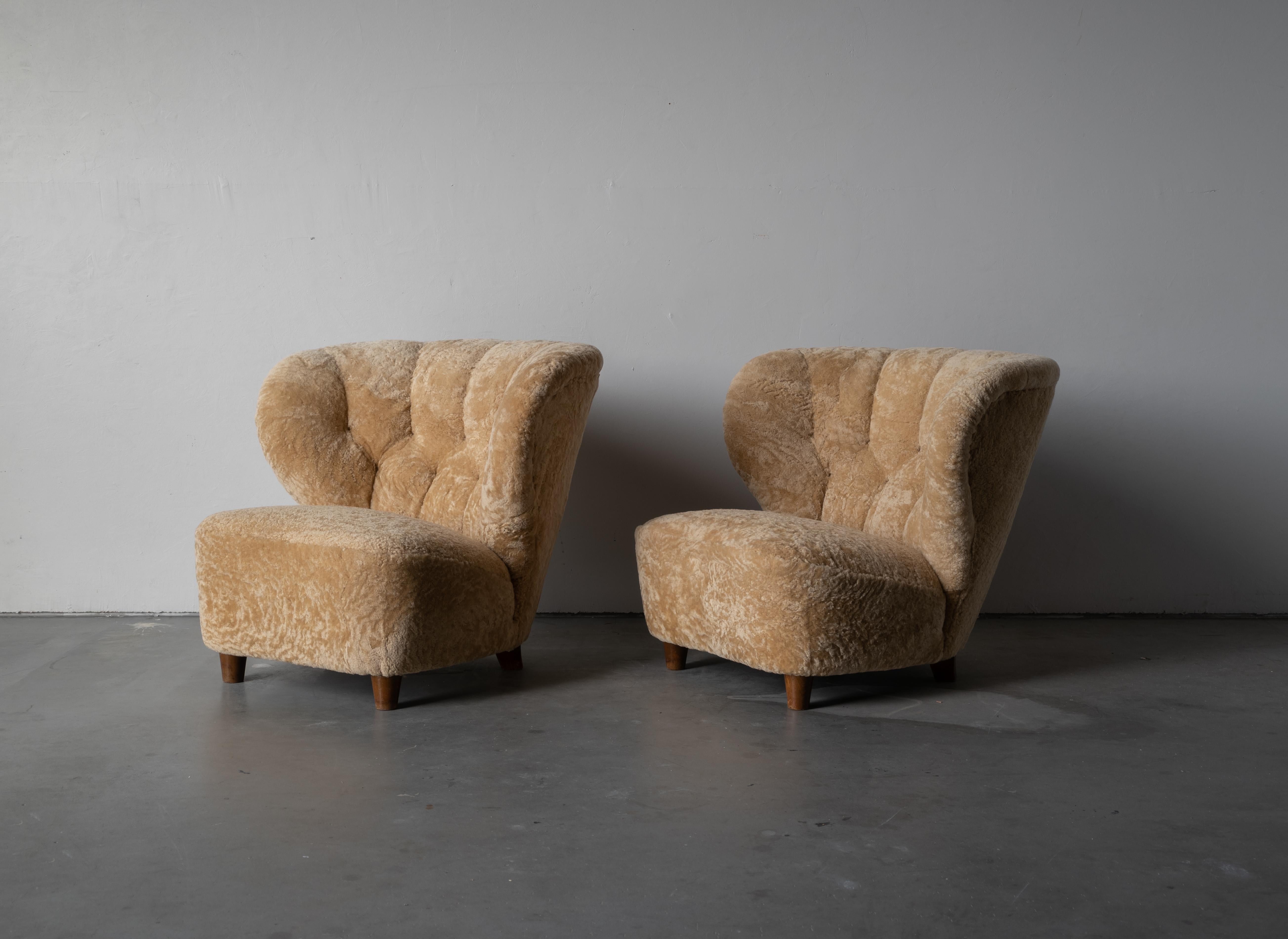 A pair of organic modernist lounge chairs / slipper chairs. Designed and produced in Finland, 1940s. Reupholstered in brand new authentic shearling upholstery. 

Similar in style to works by designers such as Flemming Lassen, Gio Ponti, Vladimir
