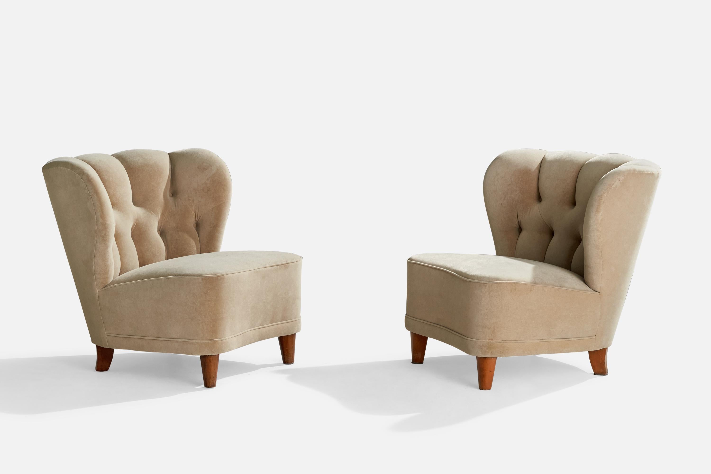 A pair of light beige fabric and wood slipper lounge chairs designed and produced in Finland, 1940s.

Seat height 15”.