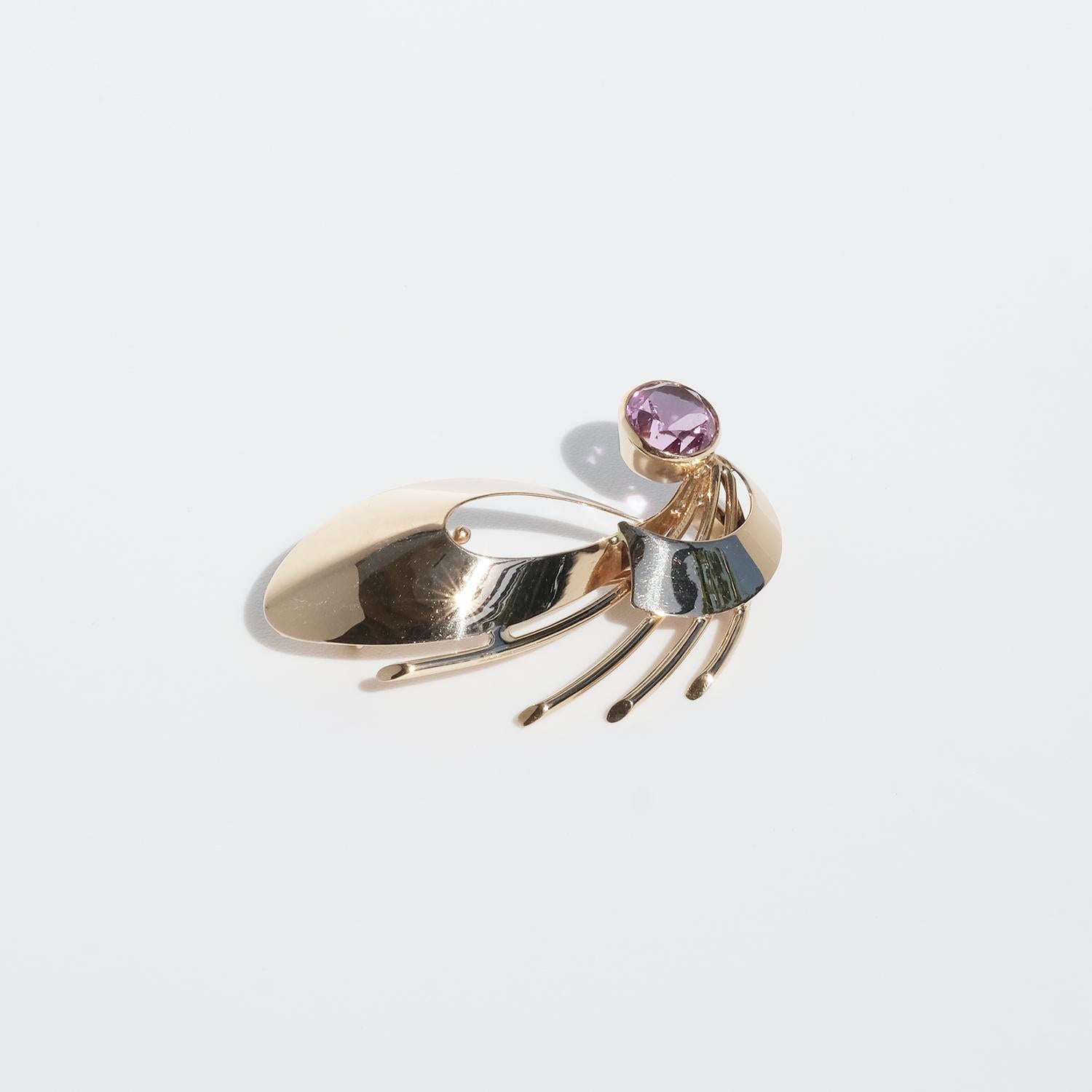 This 14 karat gold and synthetic pink sapphire has a shape resembling a beautiful dragonfly. It is fastened easily with a C clasp.

The brooch has a charming and happy look making it a perfect fit on the shirt collar or the cuff of a shirt. Or why