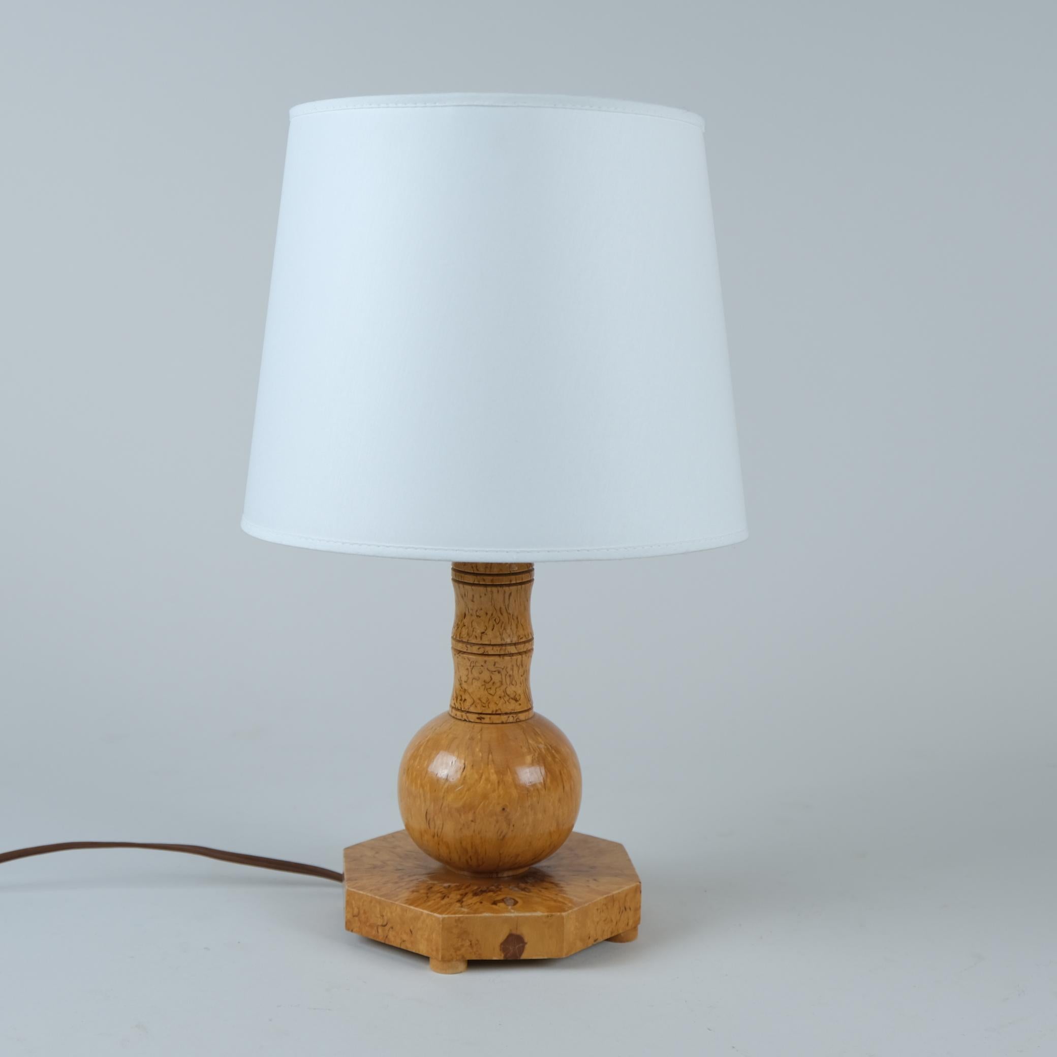 Il s'agit d'une lampe fabriquée à la main à partir d'un bouleau frisé très recherché, originaire de Finlande et de petites régions d'Europe de l'Est. Le design géométrique simple combiné à l'aspect organique et naturel du bois permet à cette lampe