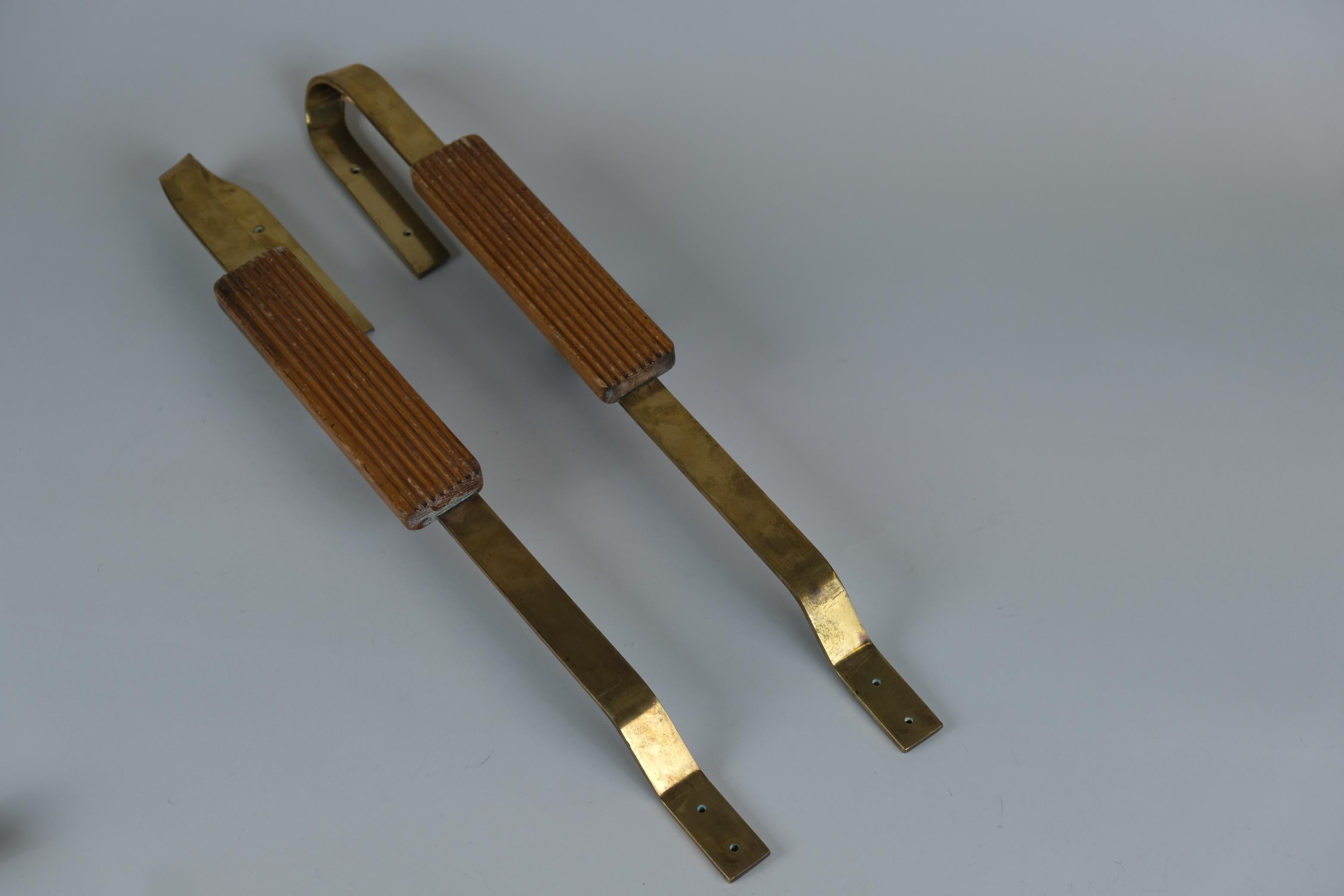 Deux élégantes poignées de porte finlandaises du milieu du 20e siècle en laiton et en bois de chêne. Les poignées sont constituées d'une bande de laiton en forme de ruban et d'une partie en bois le long de la poignée. Des pièces très pratiques mais