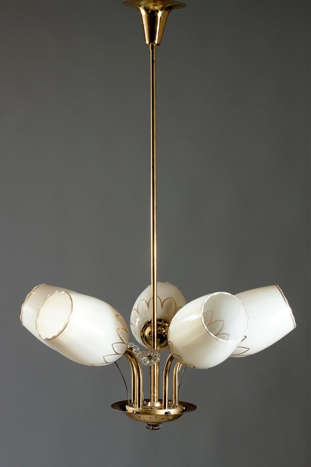 Stunning Finnish Mid-Century Modern brass chandelier with five arms in brass and decorative opaline glass shades made by Itsu in the style of Paavo Tynell. The chandelier has delicate detailed flowers made in glass.