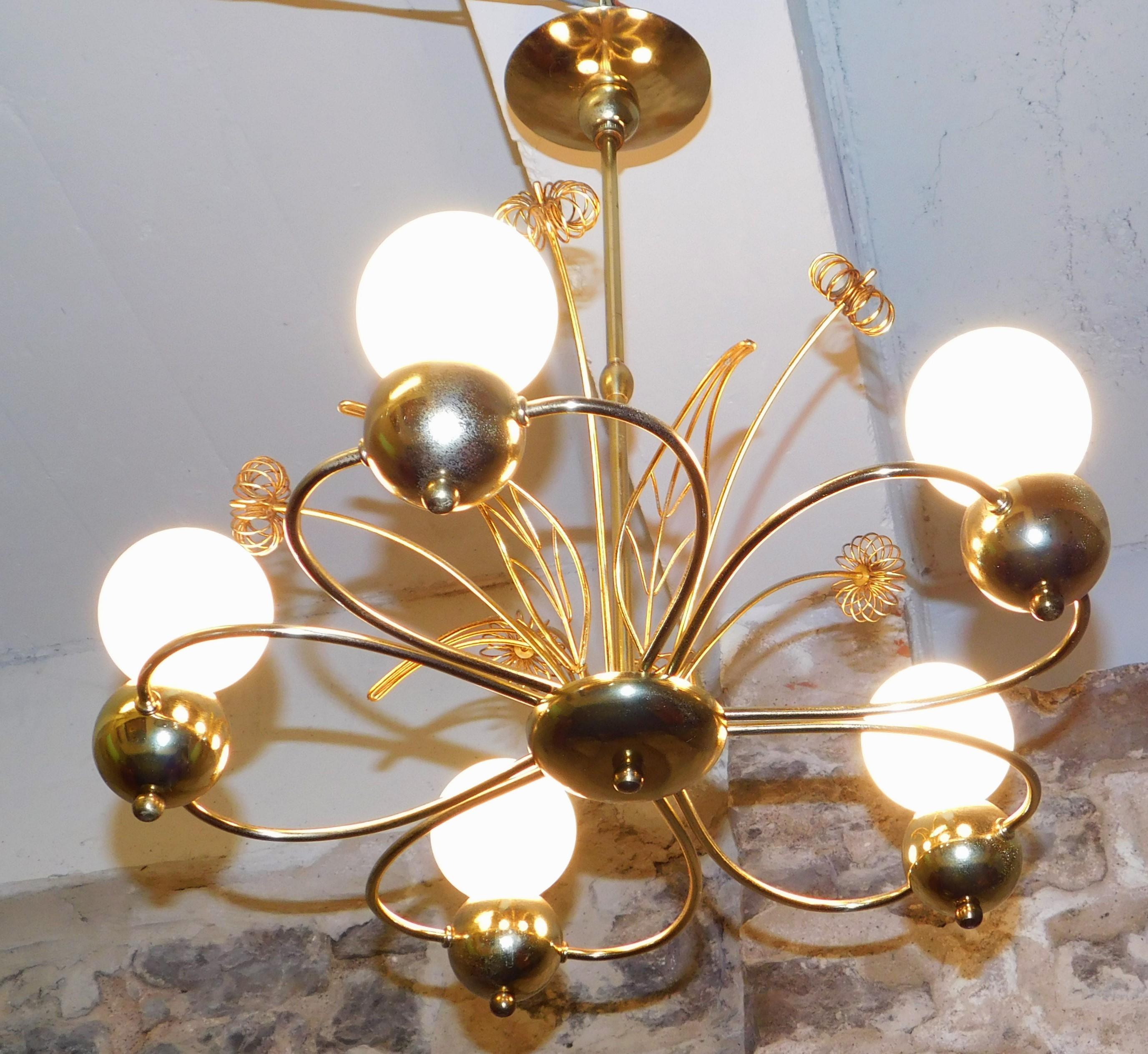 A beautiful five light brass chandelier with brass flowers attributed to Paavo Tynell.  
