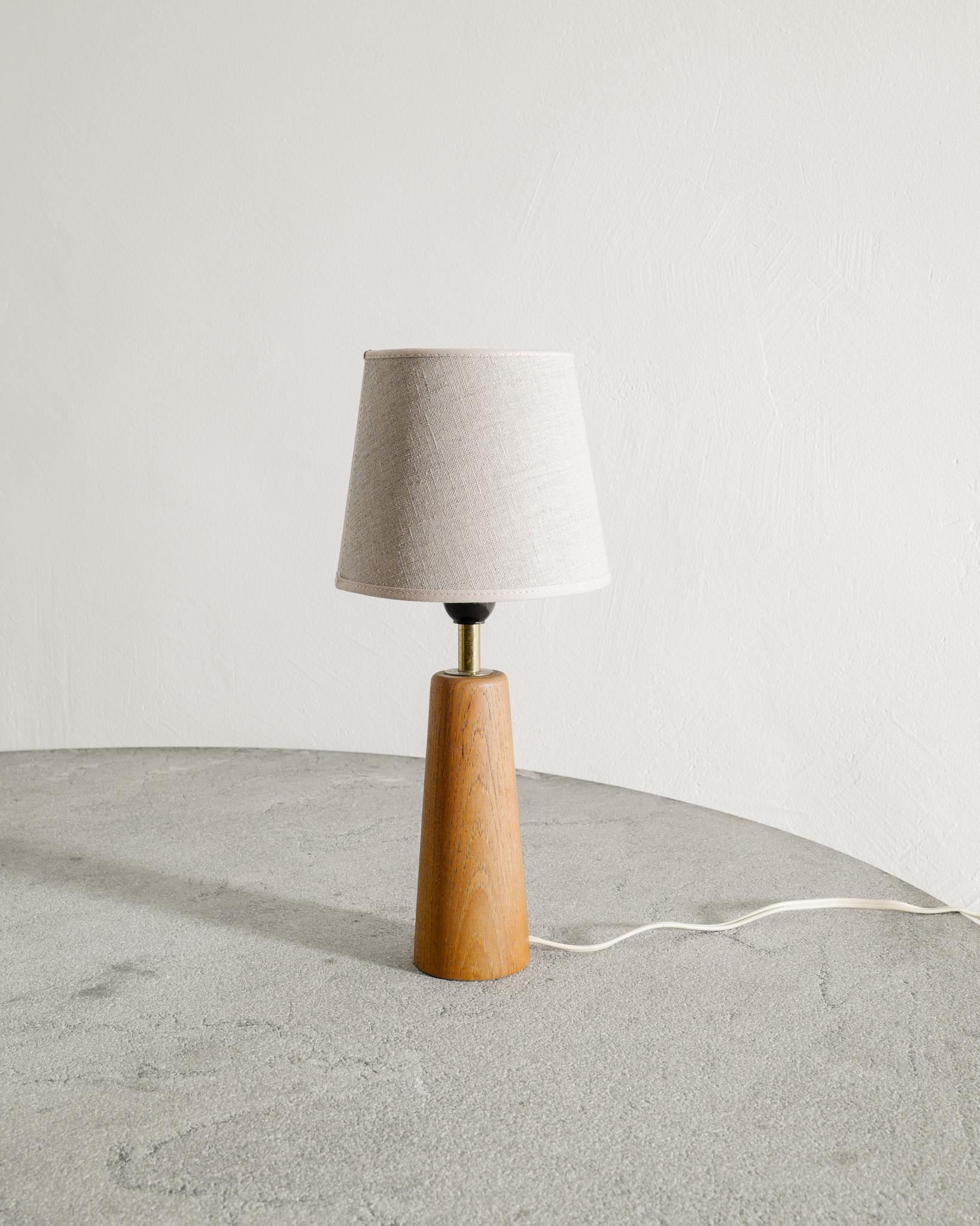 Rara lampada da tavolo in legno finlandese della metà del secolo, in teak e ottone, attribuita a Lisa Johansson-Papé e prodotta in Finlandia negli anni Quaranta. 
In buone condizioni originali. Il paralume più recente non è incluso ma può essere