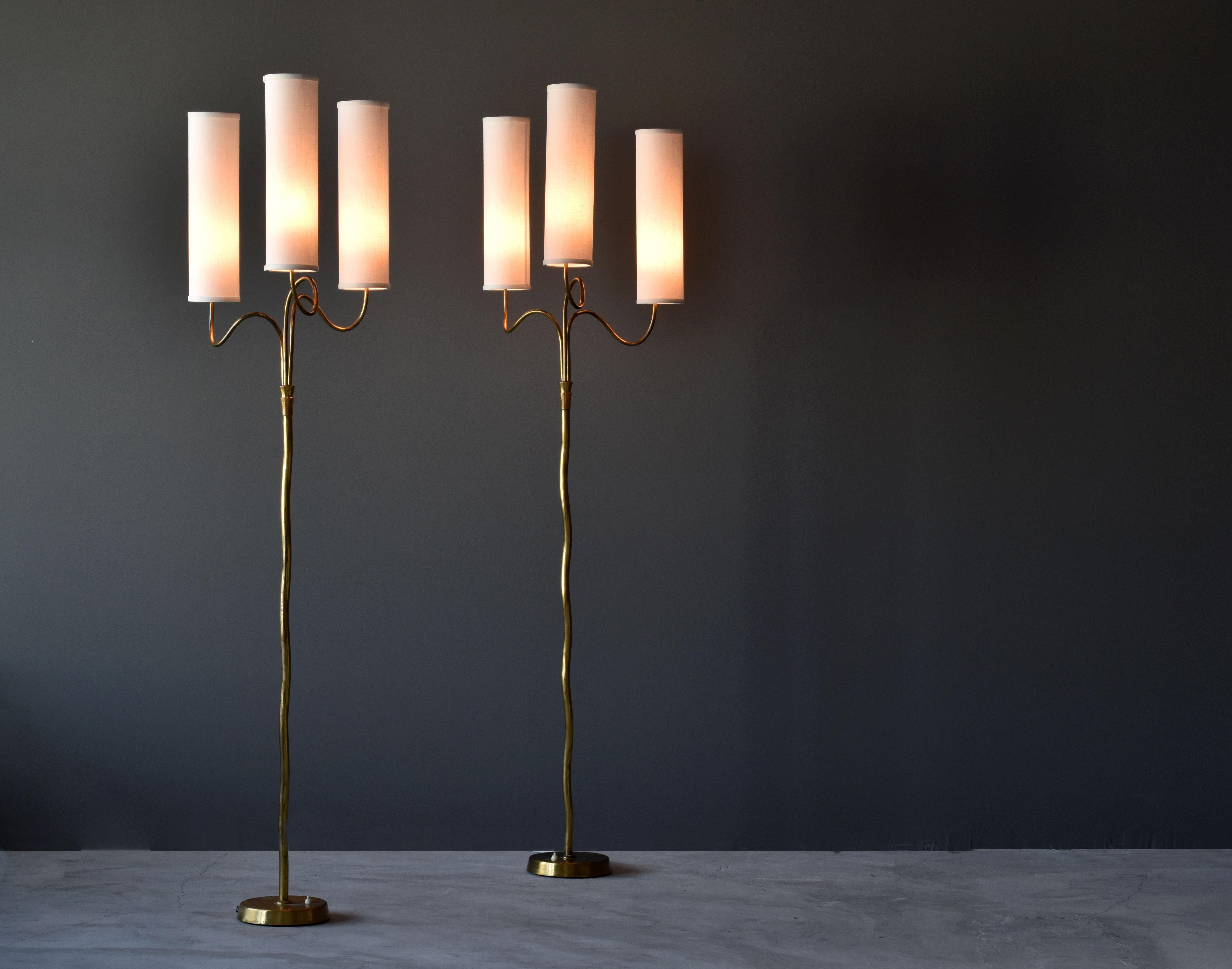 A pair of brass and fabric floor lamps, designer and manufacturer unknown. This is a prime representation of modernist lighting, Finland's strongest contribution to modernist design. 

Most likely produced in the late 1940s or early 1950s, possibly