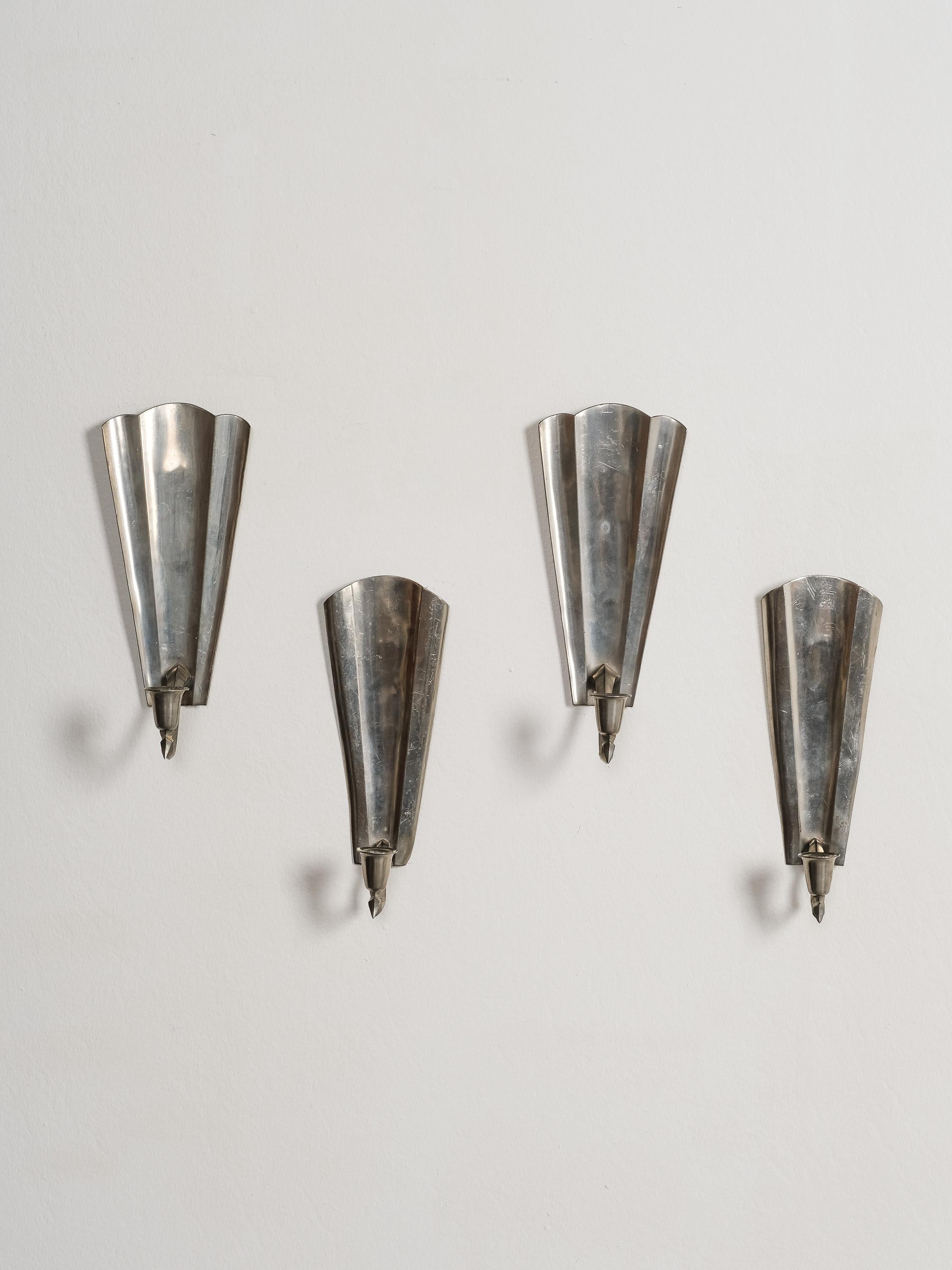 A set of four Finnish pewter wall candle sconces with angled side panels by A. Mykkänen, Taidetakomo Oy. Handcrafted in Helsinki, Finland circa 1930’s - 1940’s from high-quality solid pewter. Each one is stamped on the back. 

The set consists of