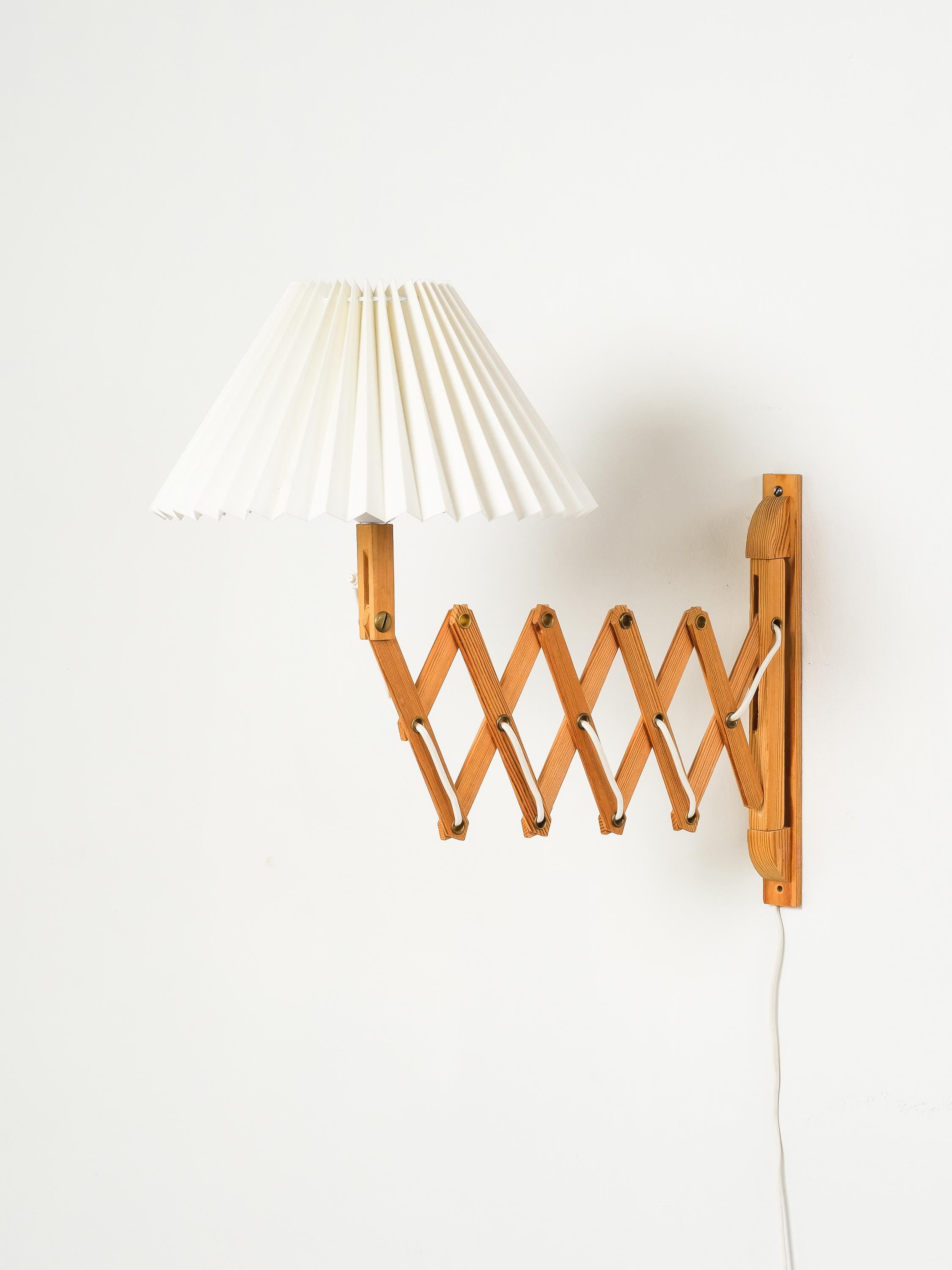 A charming Finnish wall-mounted scissor lamp from the 1960s, crafted from solid pine wood with a warm, natural finish. The extendable accordion-style arm allows the light to be adjusted with ease, offering both functionality and visual interest. It