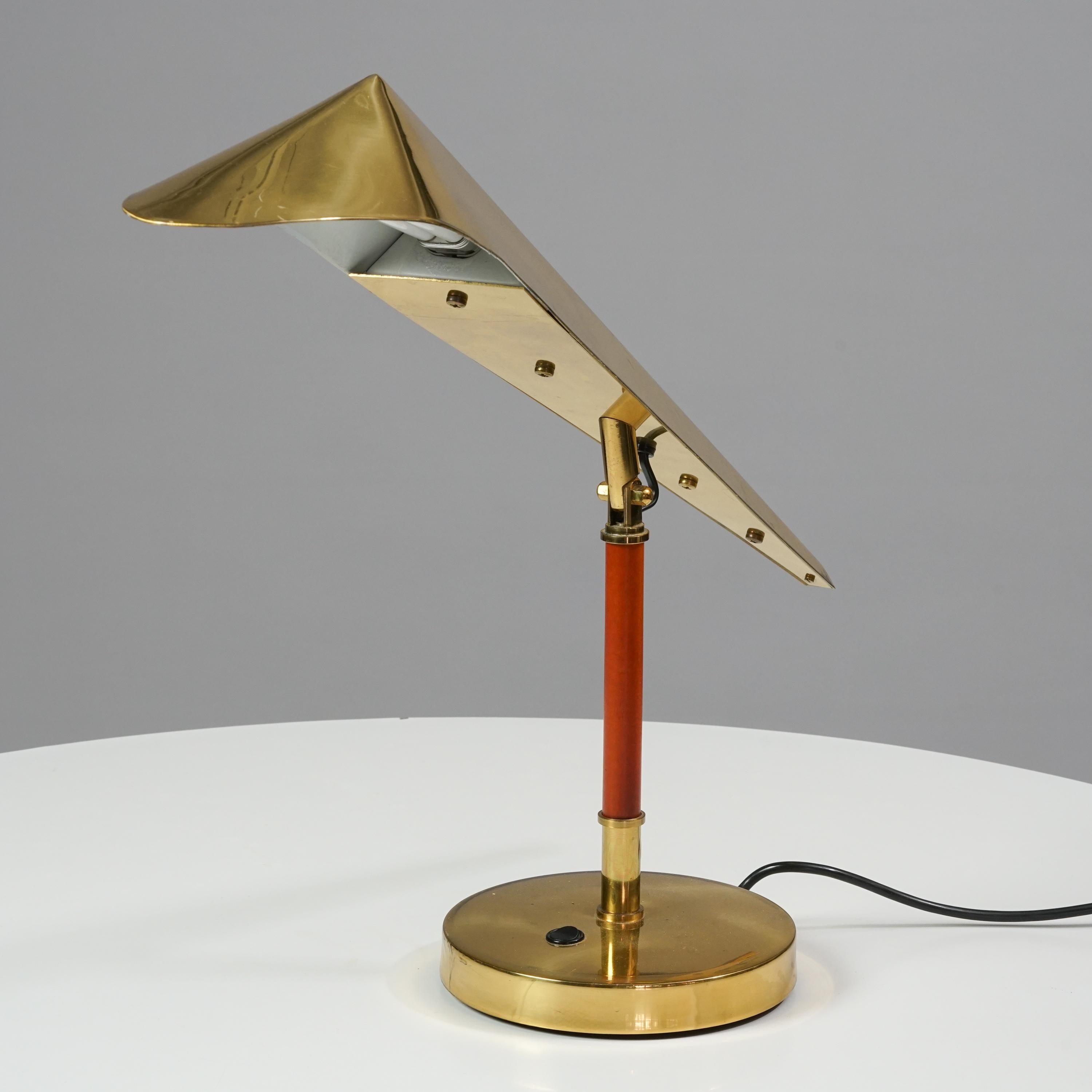 Finnish Scandinavian Modern brass table lamp by KT-Valaistus from the 1950s-1960s. Wood details. Manufacturers stamp on the bottom. The lampshade is adjustable. Paavo Tynell style design. Good vintage condition, minor wear consistent with age and