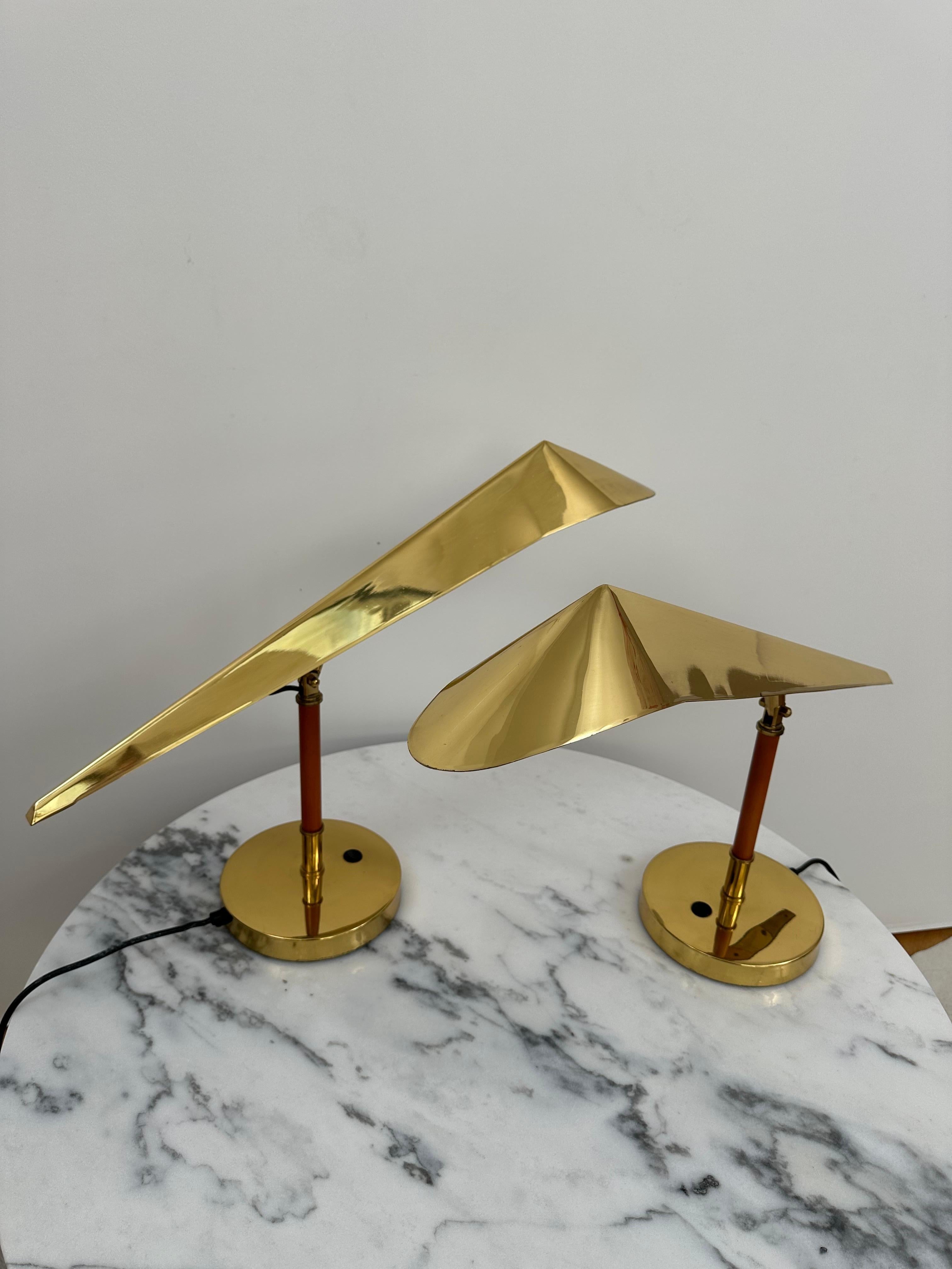 A pair of table lamps, custom order produced by KT Valaistus ( Kone-Tukku Oy) for Hotel Lappee Lappeenranta, Finland. Circa 1970's. Adjustable lamps head made of polished brass mount on teak stem. Manufacturer label attached. Existing Europeans