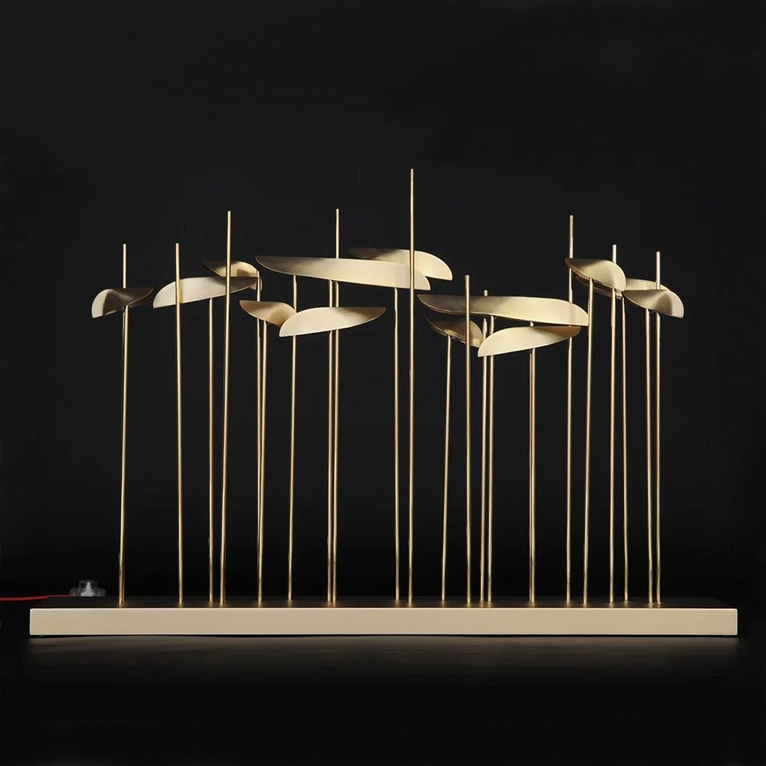 Table Lamp Fins Large with polished brass rods on metal base
in gold finish. With brass shades in satinated finish. Power
LED light source, 13x3,15W (41 W), rated luminous flux: 5135 Lm, 
3000° K.