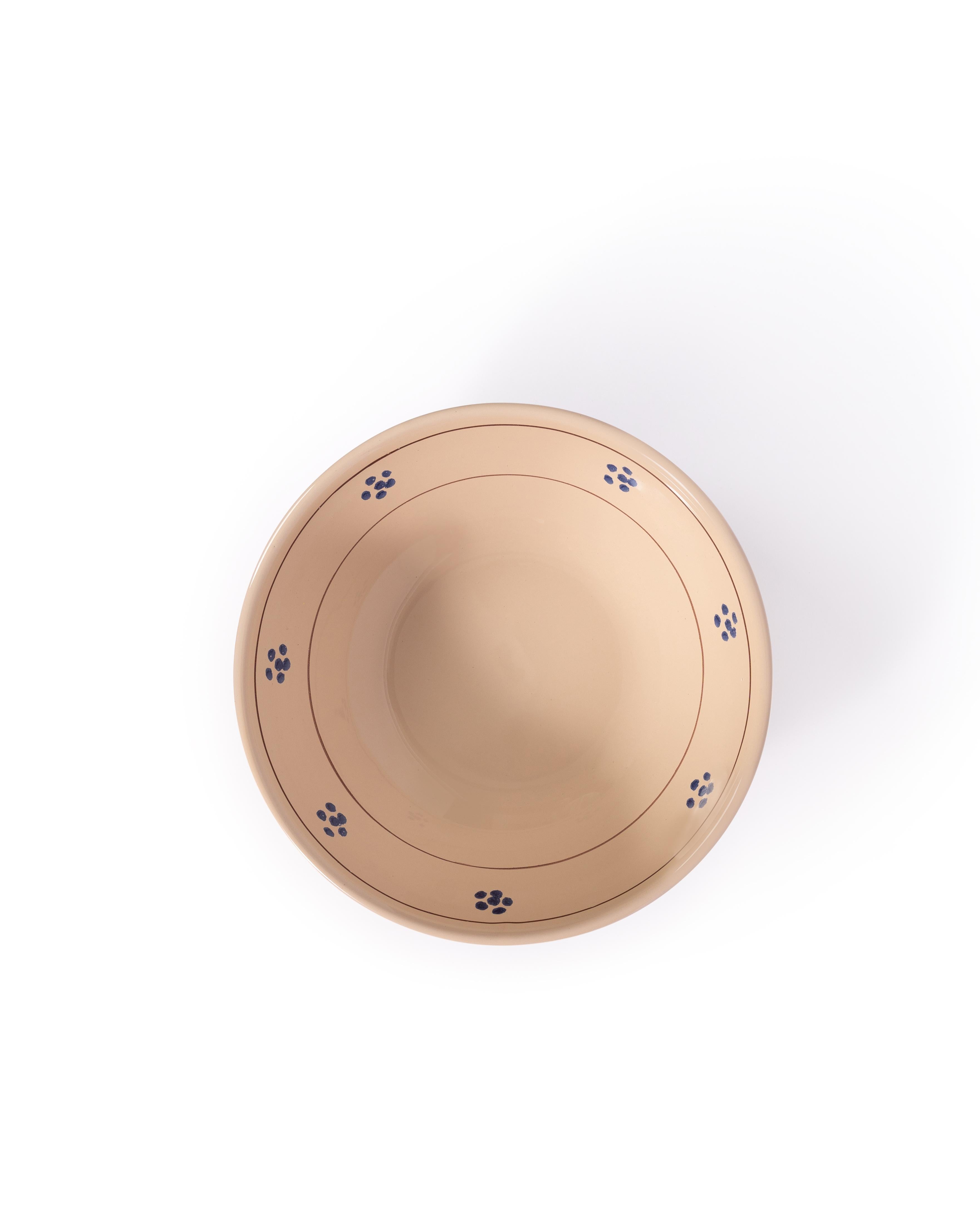 Une collection de table chaleureuse et charmante mettant en scène notre fleur bleue, un motif typique des céramiques du sud de l'Italie. Fabriquée à la main par nos artisans talentueux, la collection complète d'assiettes, de bols, de plateaux, de