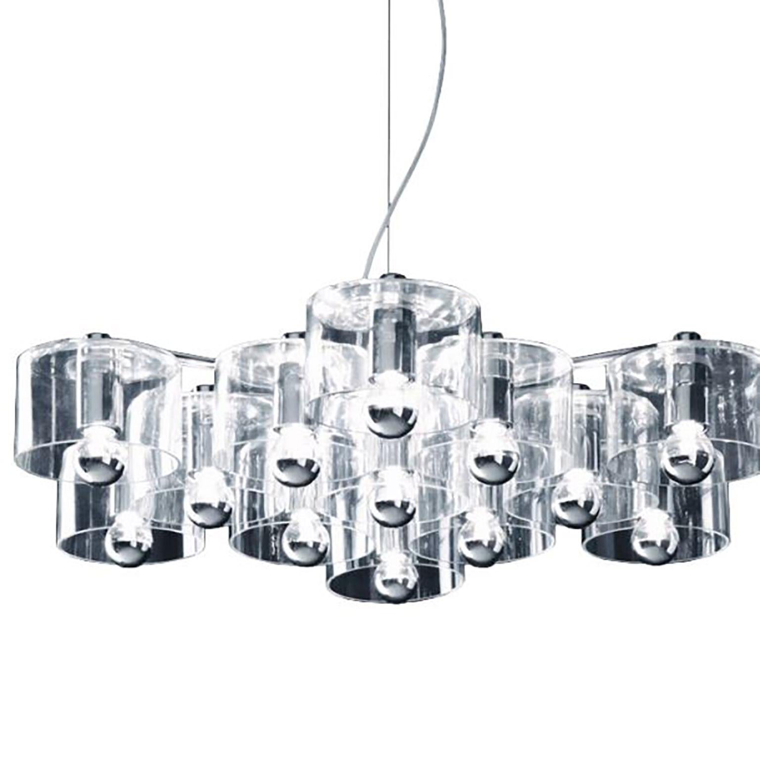 Suspension Fiore conçue par Marta Laudani & Marco Romanelli pour Oluce. La lampe se compose de cylindres en verre transparent qui se raccordent à un corps métallique, créant une forme qui ressemble à une fleur stylisée. Le métal et le verre soufflé