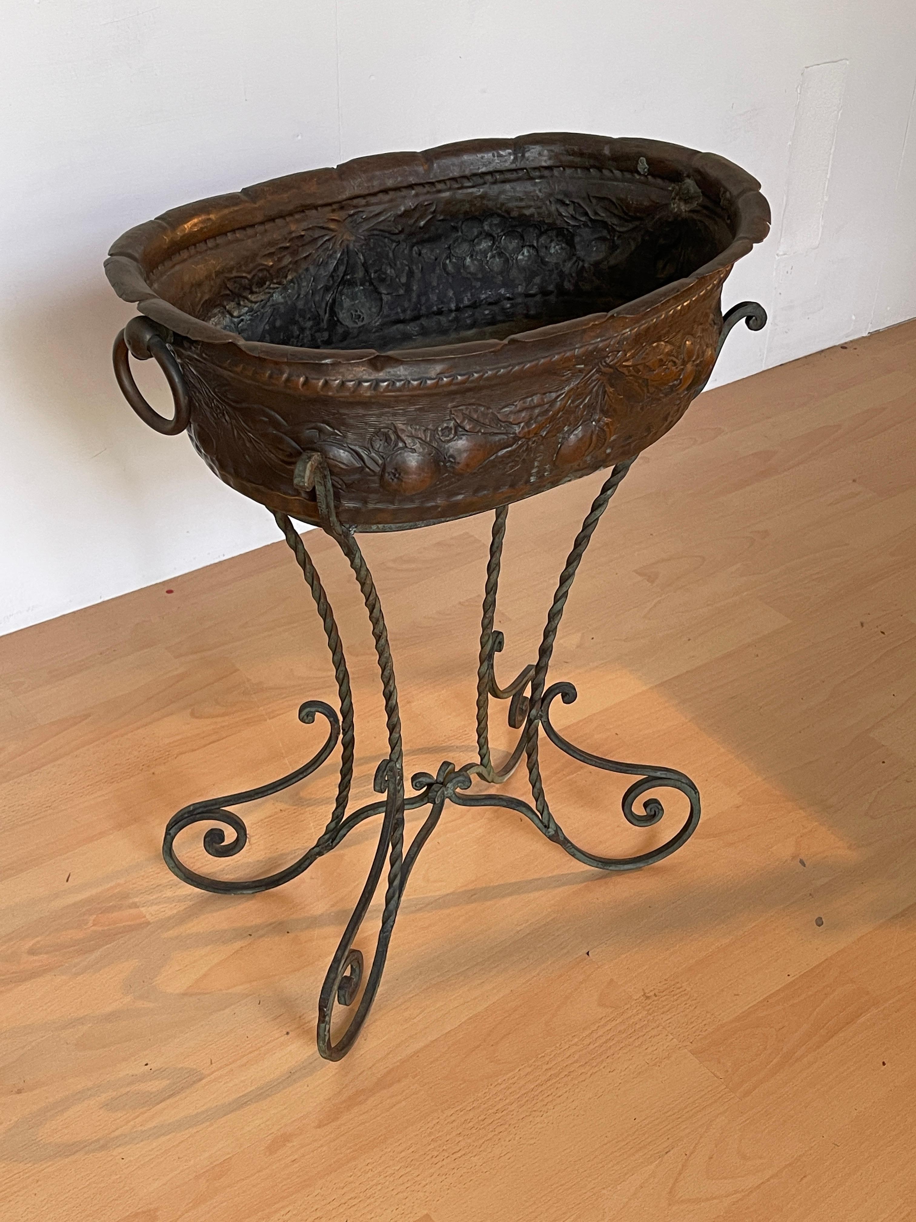Elegante fioriera in bronzo con base a piedi intrecciati è un pezzo raffinato che aggiungerà un tocco di classe a qualsiasi ambiente. La vasca, finemente decorata con motivi floreali e frutti intagliati, esprime un'arte metallica di alta qualità,