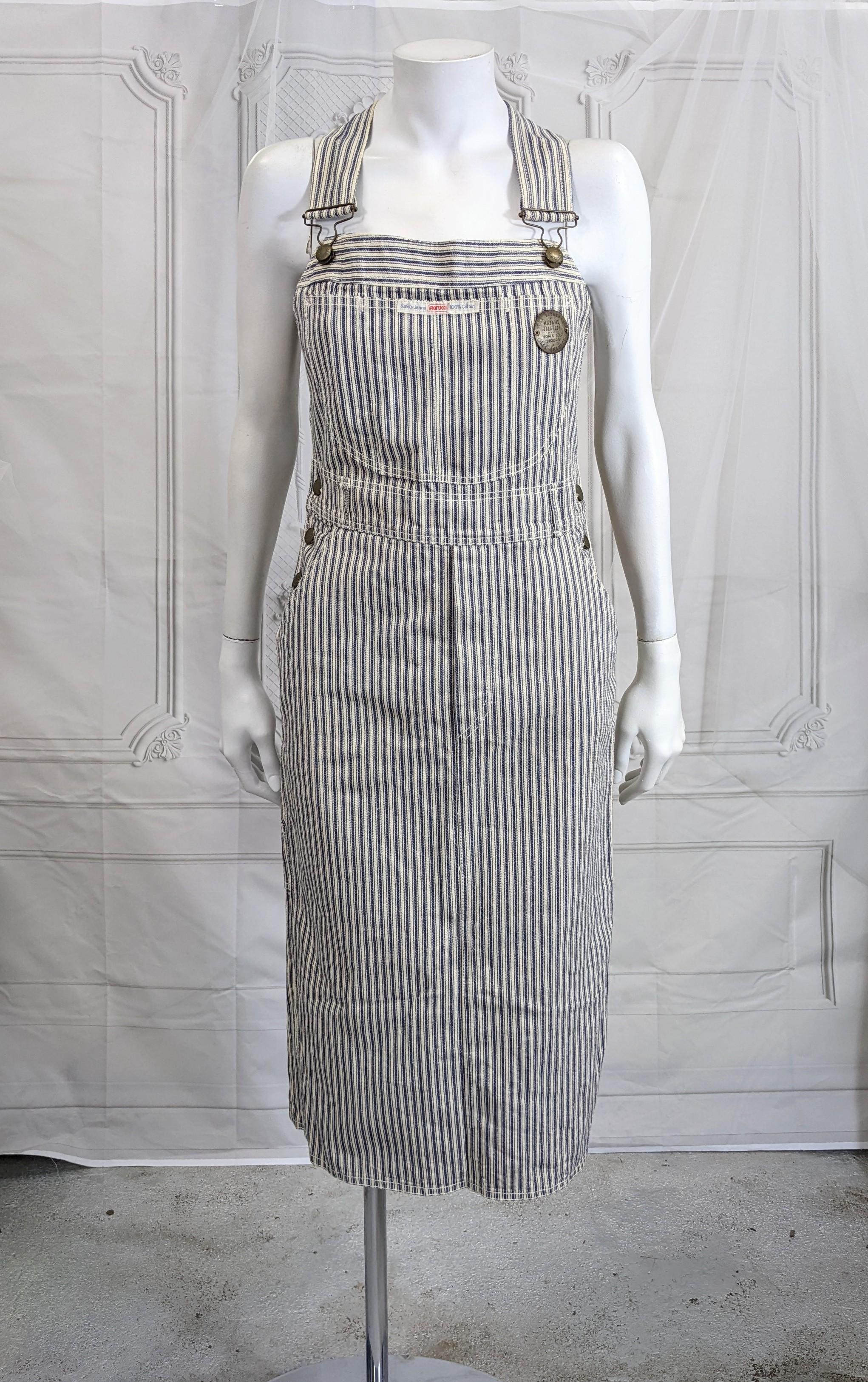 Fiorucci Cotton Denim Ticking Striped Overall Dress from the 1980's. Classic overall styling with tons of amazing, lovely details and stitching. Crossed back straps, faux fly and even, loops for a belt.  Vintage Size 40. 1980's Italy.
Bust 31