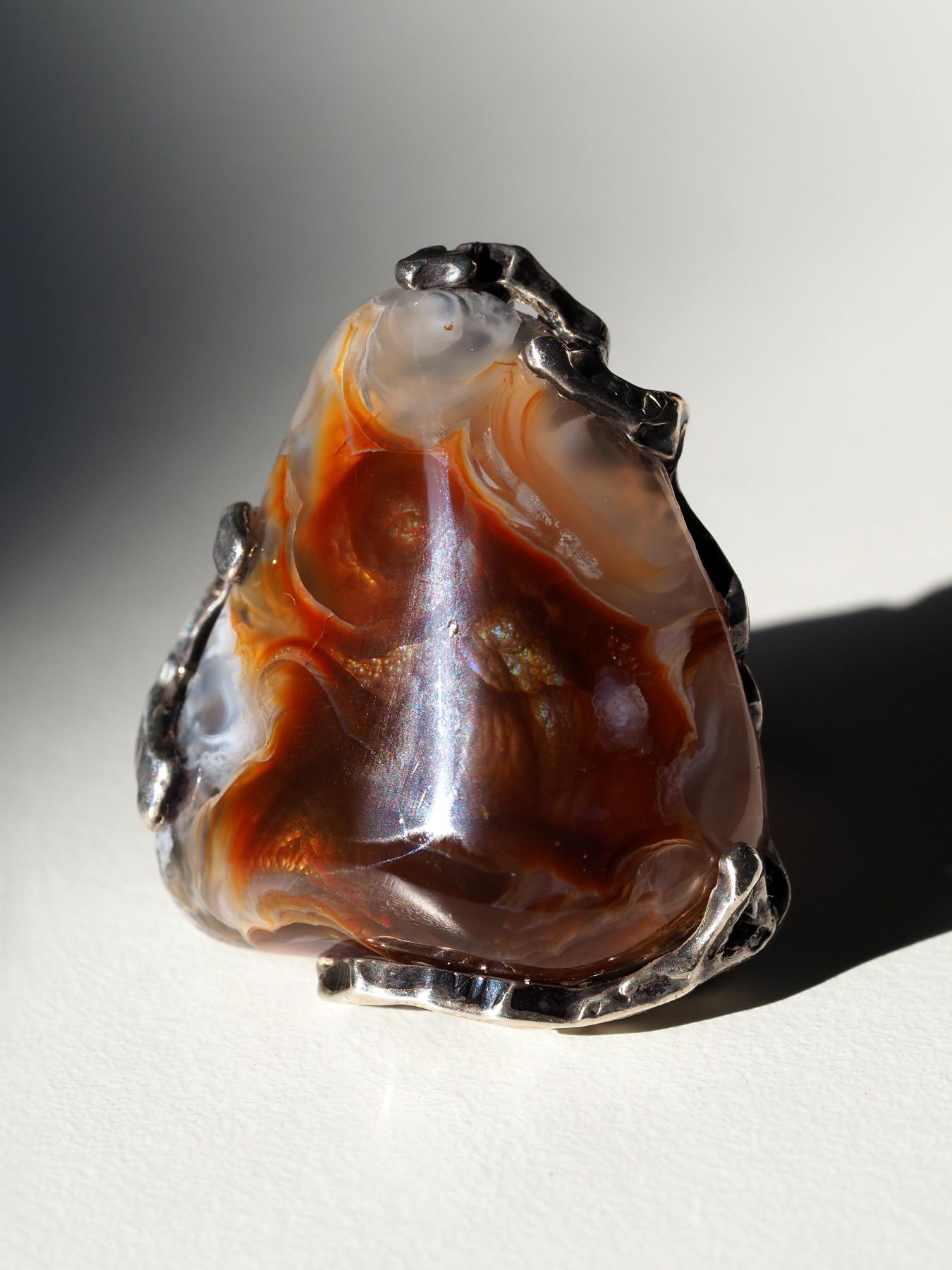 Dieser auffällige, einzigartige Silberring zeigt einen dramatischen, natürlichen Feuerachat, der aus Mexiko stammt und eine beeindruckende Größe von 30 × 32 mm (1,18 × 1,26 Zoll) hat. Der Cabochon zeigt das charakteristische schillernde Farbenspiel