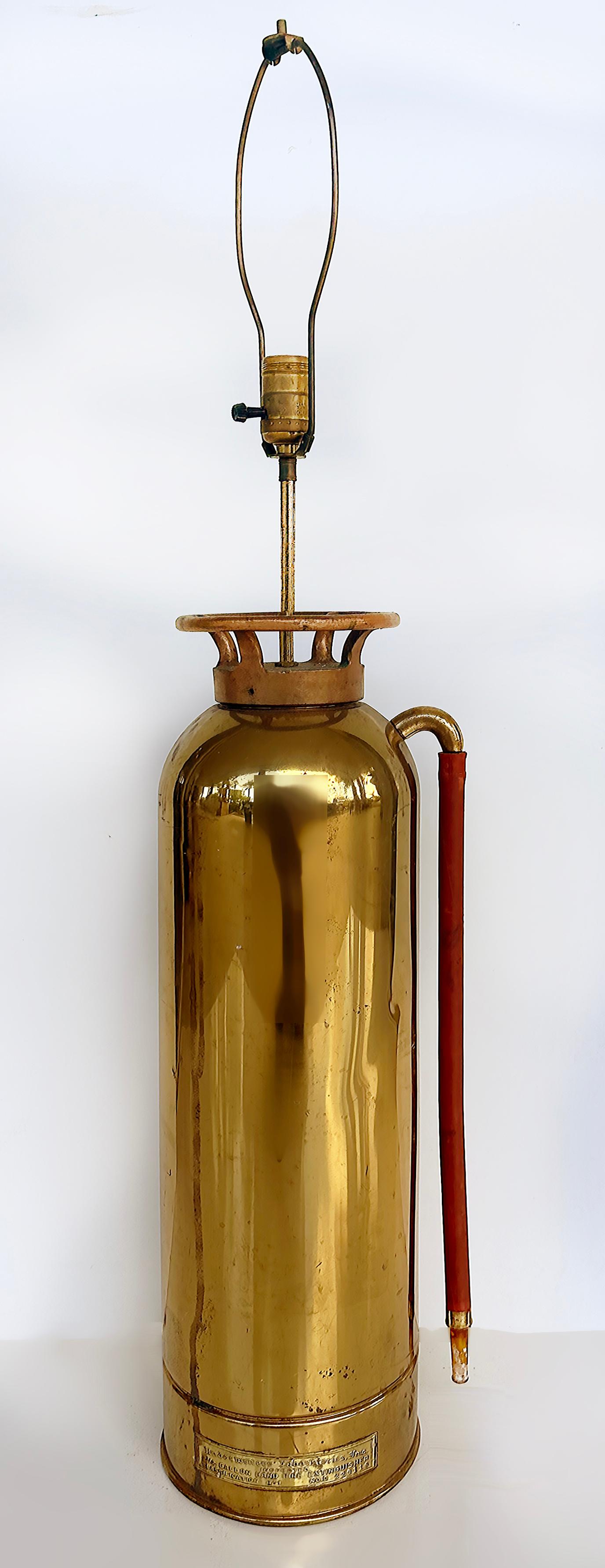 Antike Feuerlöscher Tischlampe aus Messing und Kupfer

Zum Verkauf angeboten wird ein antiker Feuerlöscher aus poliertem Messing und Kupfer, der Mitte des 20. Jahrhunderts in eine Tischlampe umgewandelt wurde. Der Feuerlöscher ist mit einer Plakette