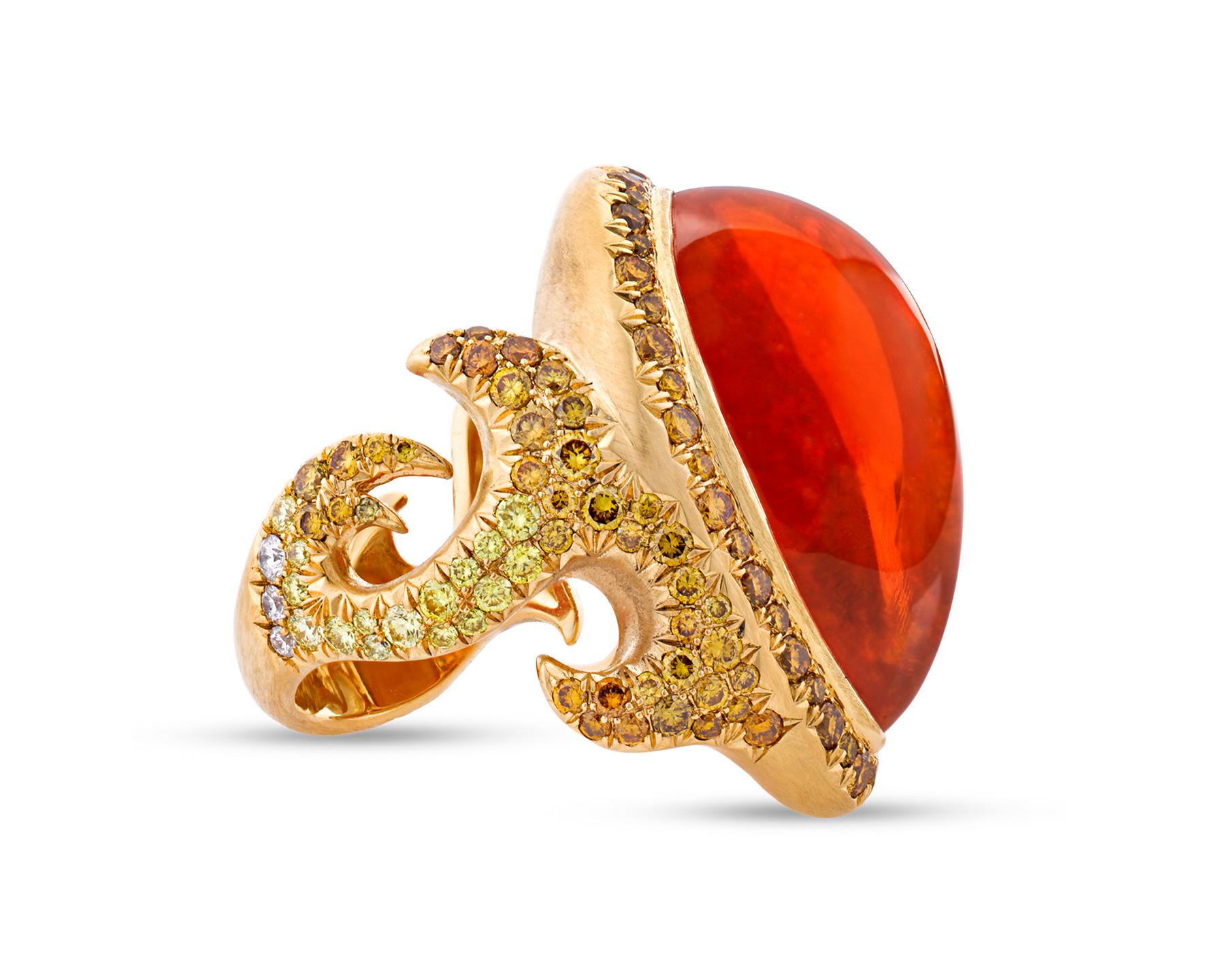 This breathtaking ring boasts a brilliant 24.39-carat fire opal cabochon centerpiece displayed in a rare and beautiful design. An eye-catching array of 157 stunning melee diamonds weighing 2.74 carats total accent this vibrant orange opal. Crafted