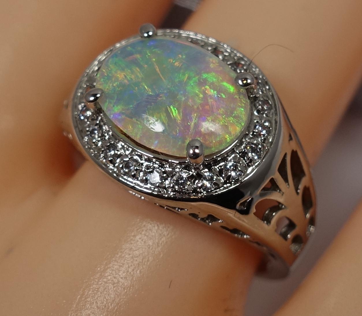 This ring features a cabochon cut fire opal with diamond accents in a 14kt white gold setting.  A size 7, this ring measures 1/2” across the top and is in excellent condition.