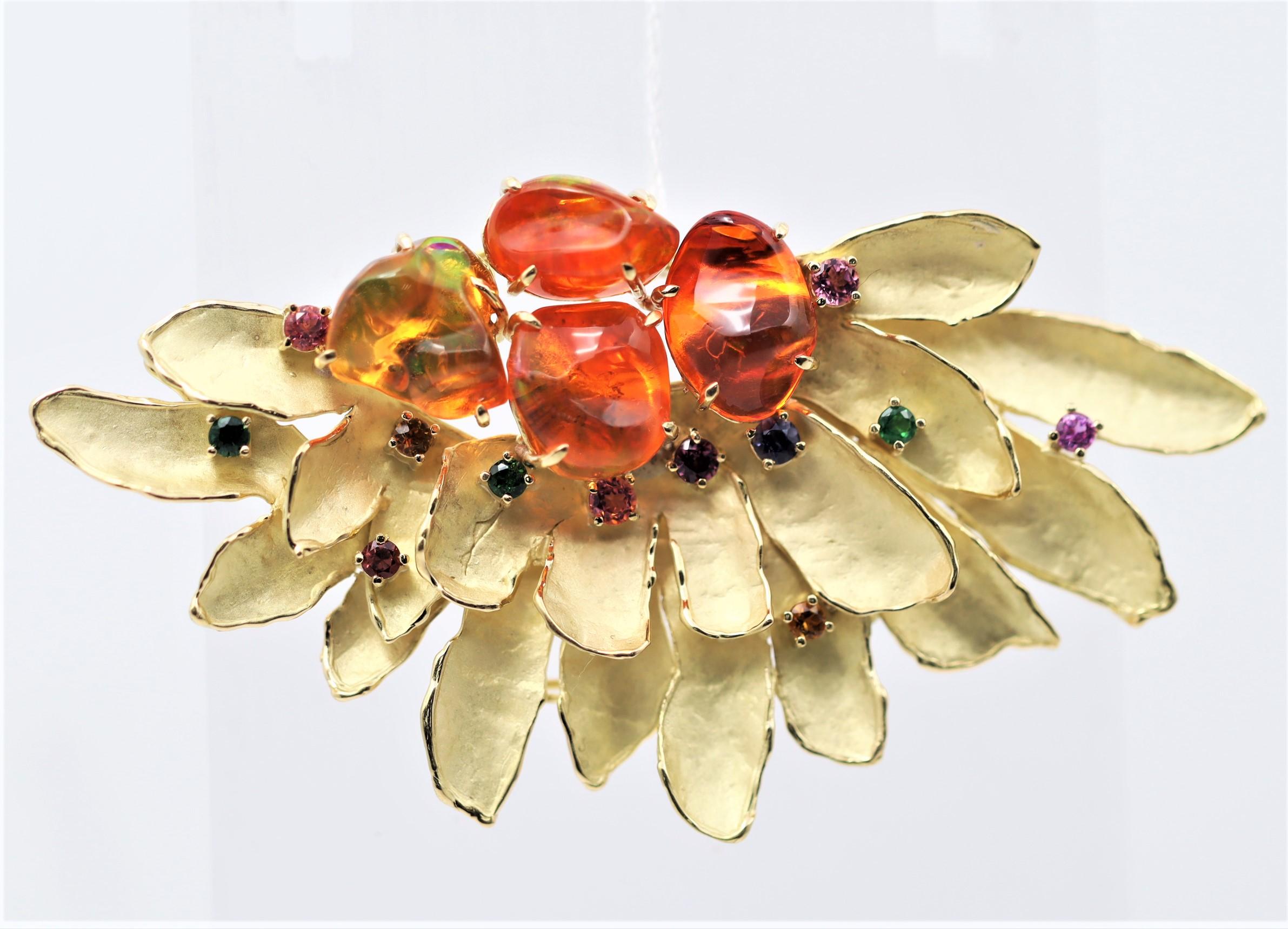 A fun and colorful piece featuring 4 fire opals with a rich vibrant orange color weighing a total of 12.90 carats. Adding to that are multi-colored sapphires set around the piece which weigh a total of 1.18 carats. Made in 18k yellow gold, the piece