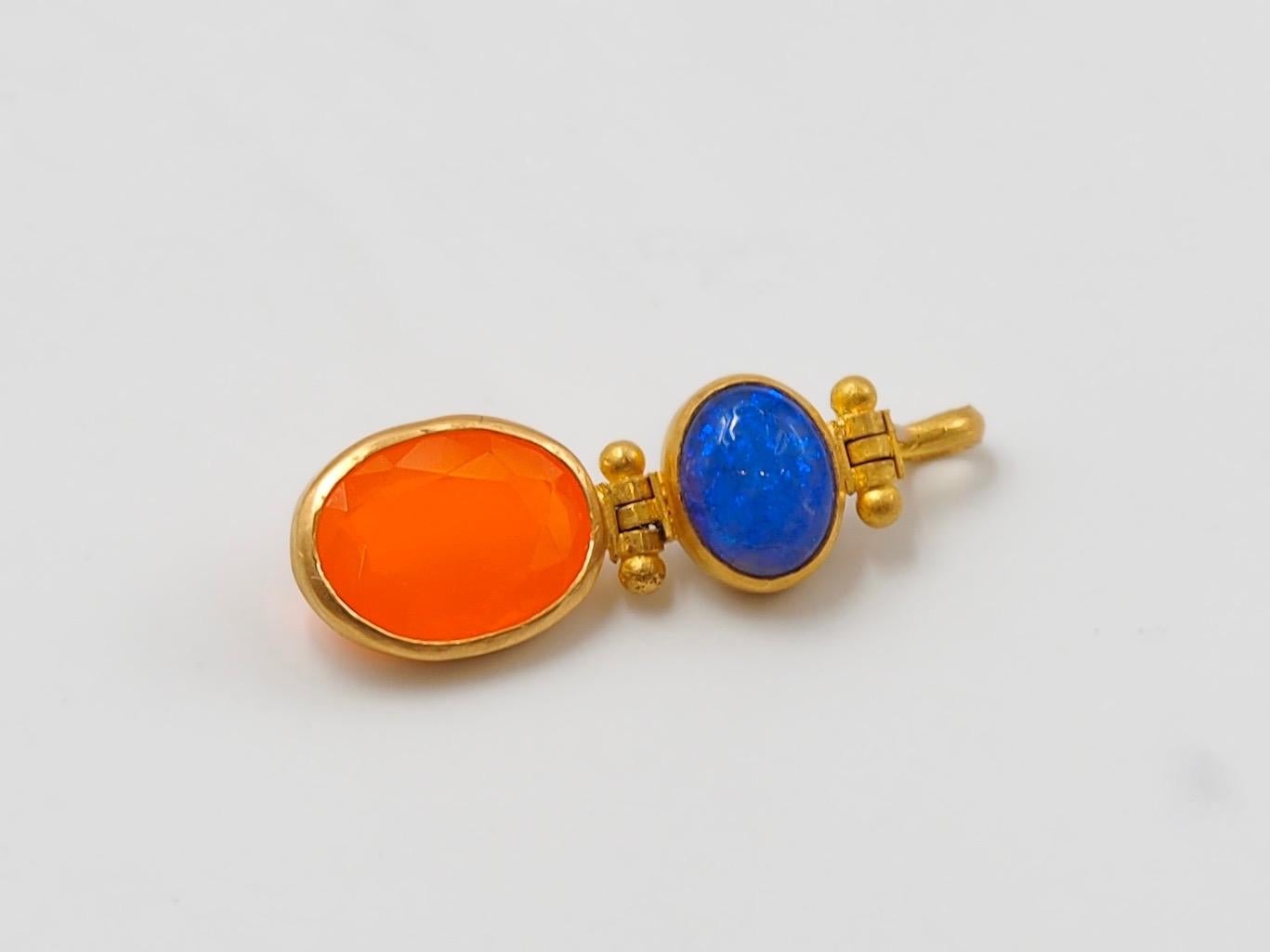 This pendant is composed of a blue opal (doublet) of 1.31 cts and a fire opal of 1.82 cts. Opal is a fragile stone that should be worn with attention.
Between the stones and at the top part, the pendant has 2 swivels mechanisms to allow good